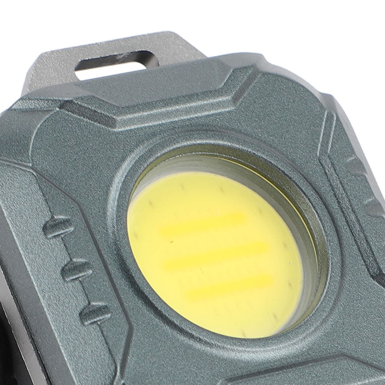 Nahaufnahme einer grauen Taschenlampe mit hellem gelbem LED-Licht. Die Oberfläche ist strukturiert.