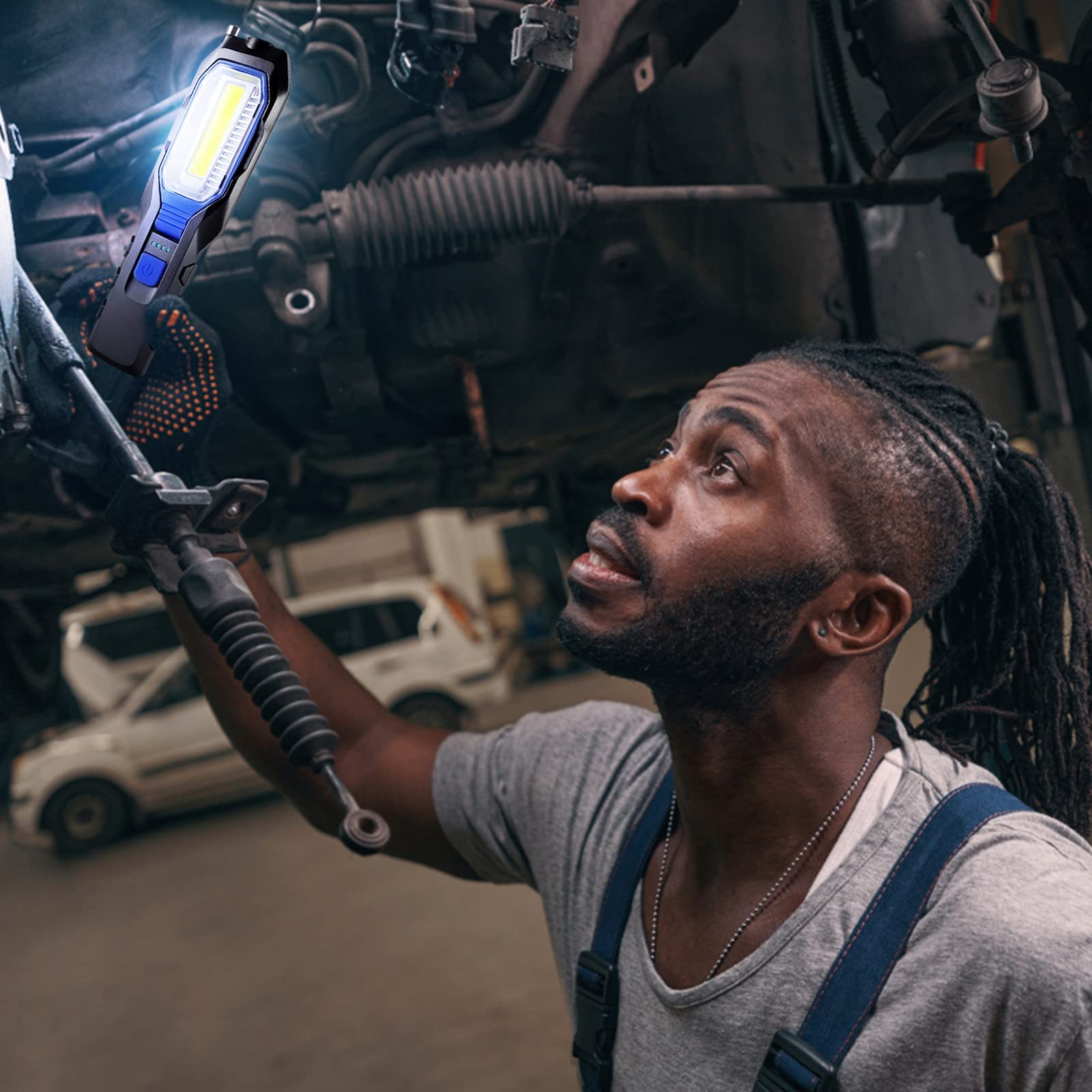 Mechaniker inspiziert Autoteile mit einer Taschenlampe. Dunkler, detaillierter Hintergrund.