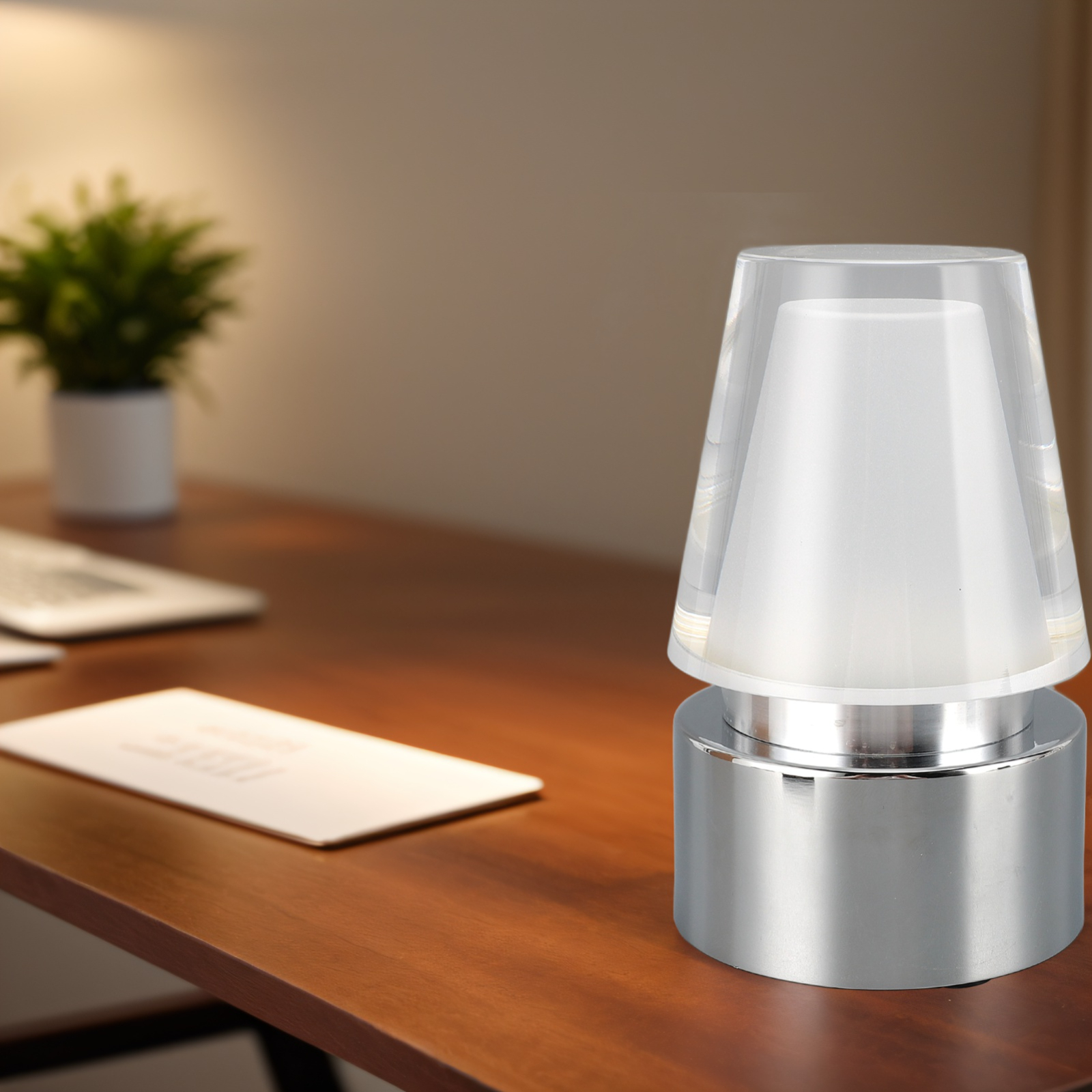 Nahaufnahme einer weißen und silbernen Nachttischlampe auf einem braunen Schreibtisch mit unscharfem Hintergrund.