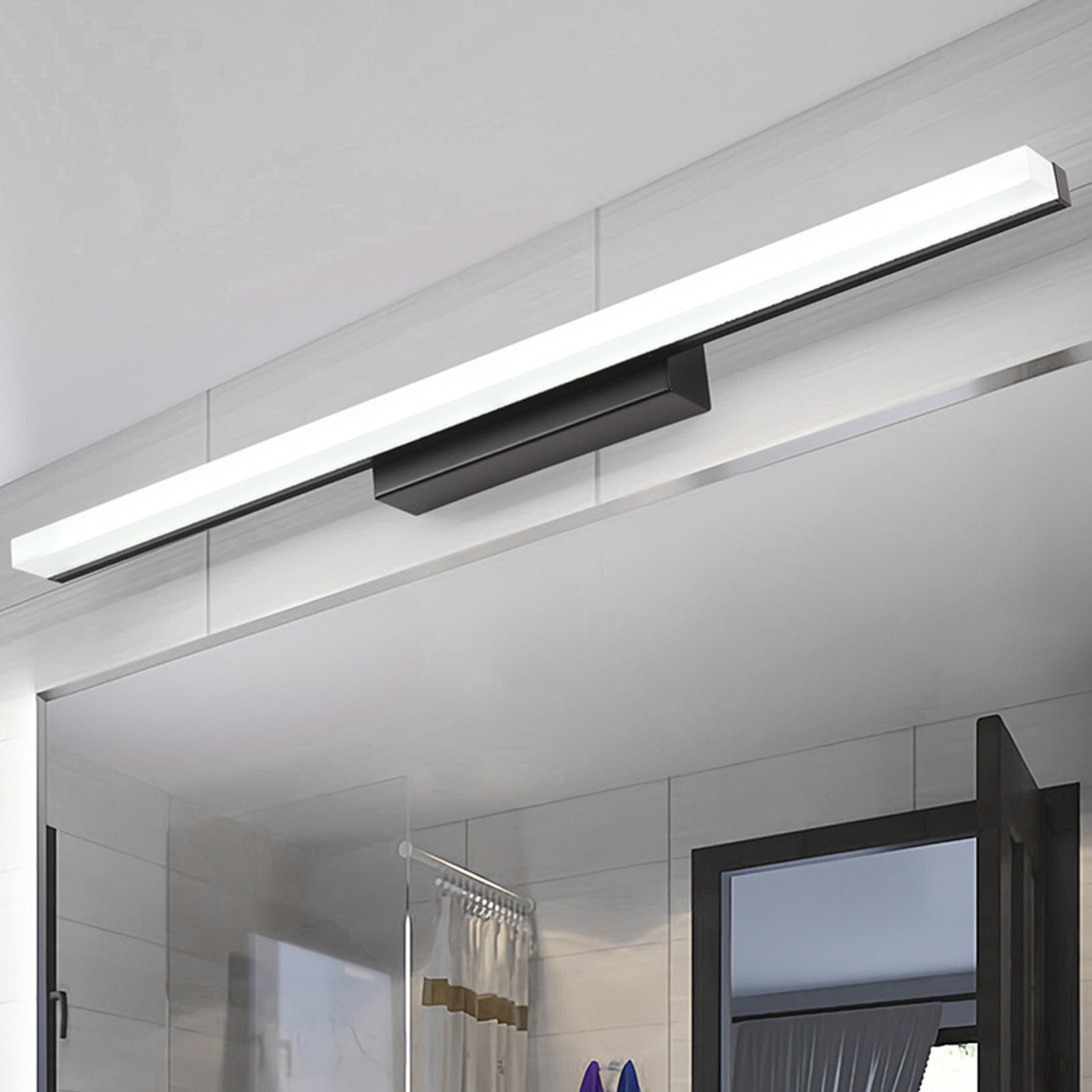 Badezimmer-Leuchte mit schwarzem Sockel und langem weißem Licht. Die Decke ist weiß.
