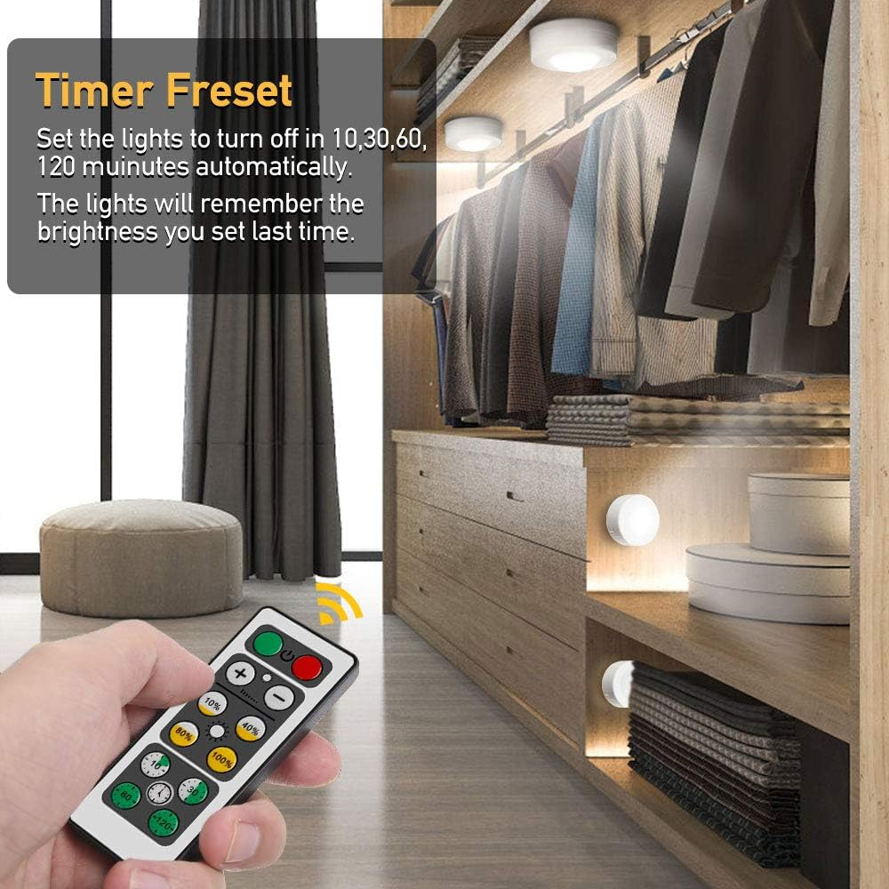 Eine Hand hält eine Fernbedienung mit Timer-Optionen. Ein Schrank mit Lichtern ist im Hintergrund.