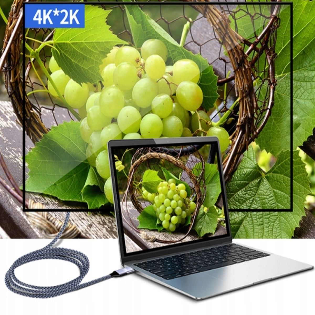 Laptop wyświetla winogrona w koszu, z podłączonym kablem. Widoczna etykieta 4K*2K.