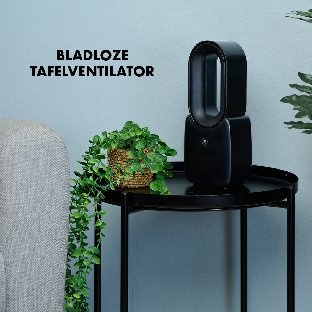 Black bladeless fan and a green plant on a black table.