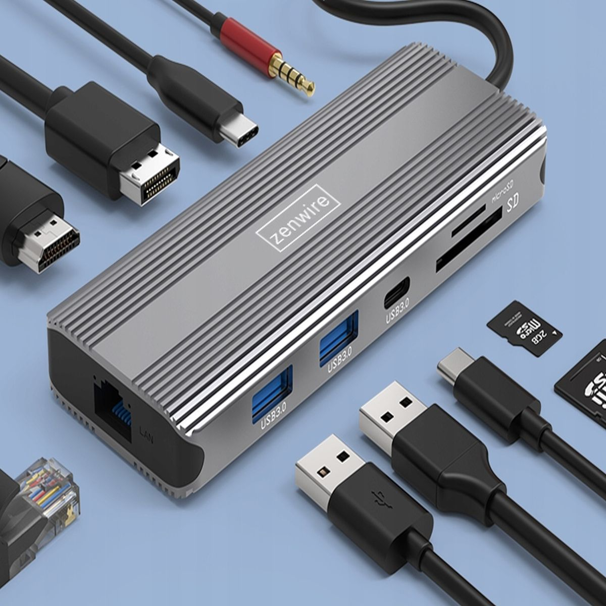 Srebrny hub USB z wieloma portami. Kable i złącza są podłączone. Niebieskie tło.
