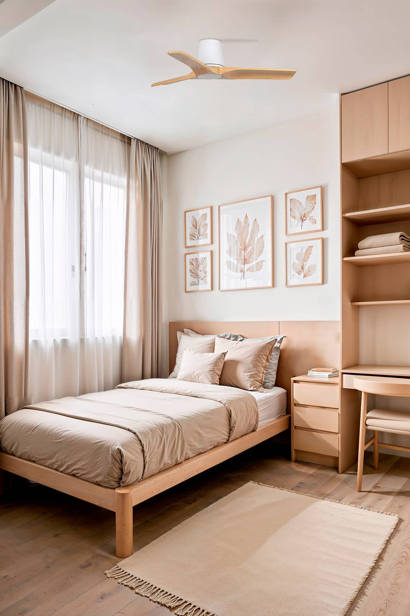 Ein Schlafzimmer mit Bett, Nachttisch und Schreibtisch. Die Wände sind beige, und es gibt gerahmte Bilder.