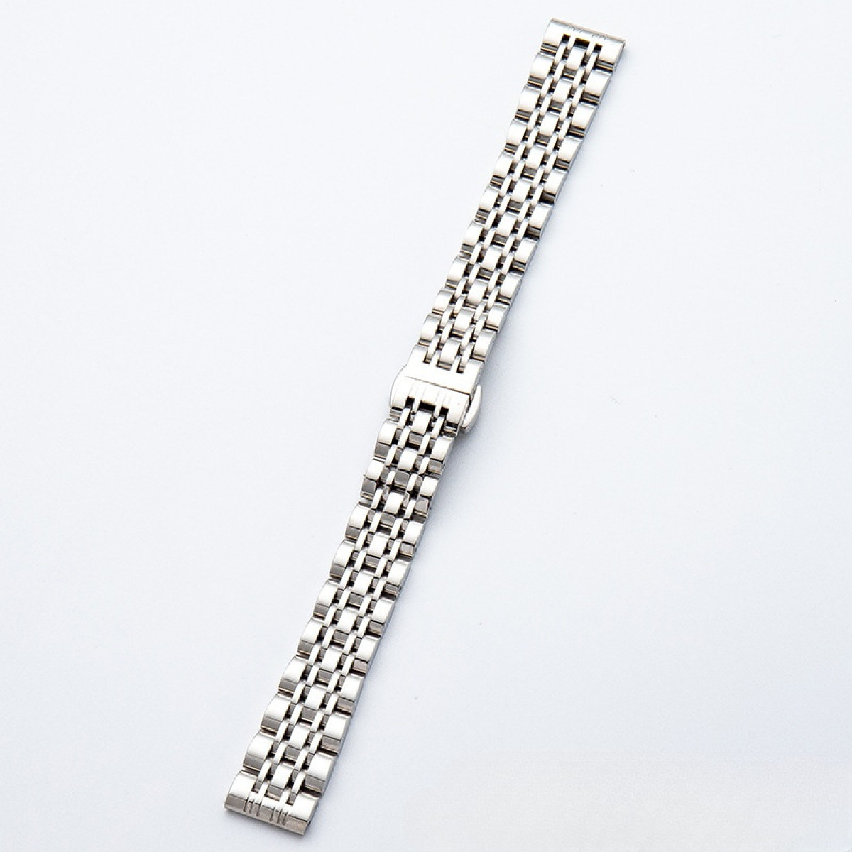 Silbernes Uhrenarmband auf Weiß. Es besteht aus kleinen, rechteckigen Gliedern.
