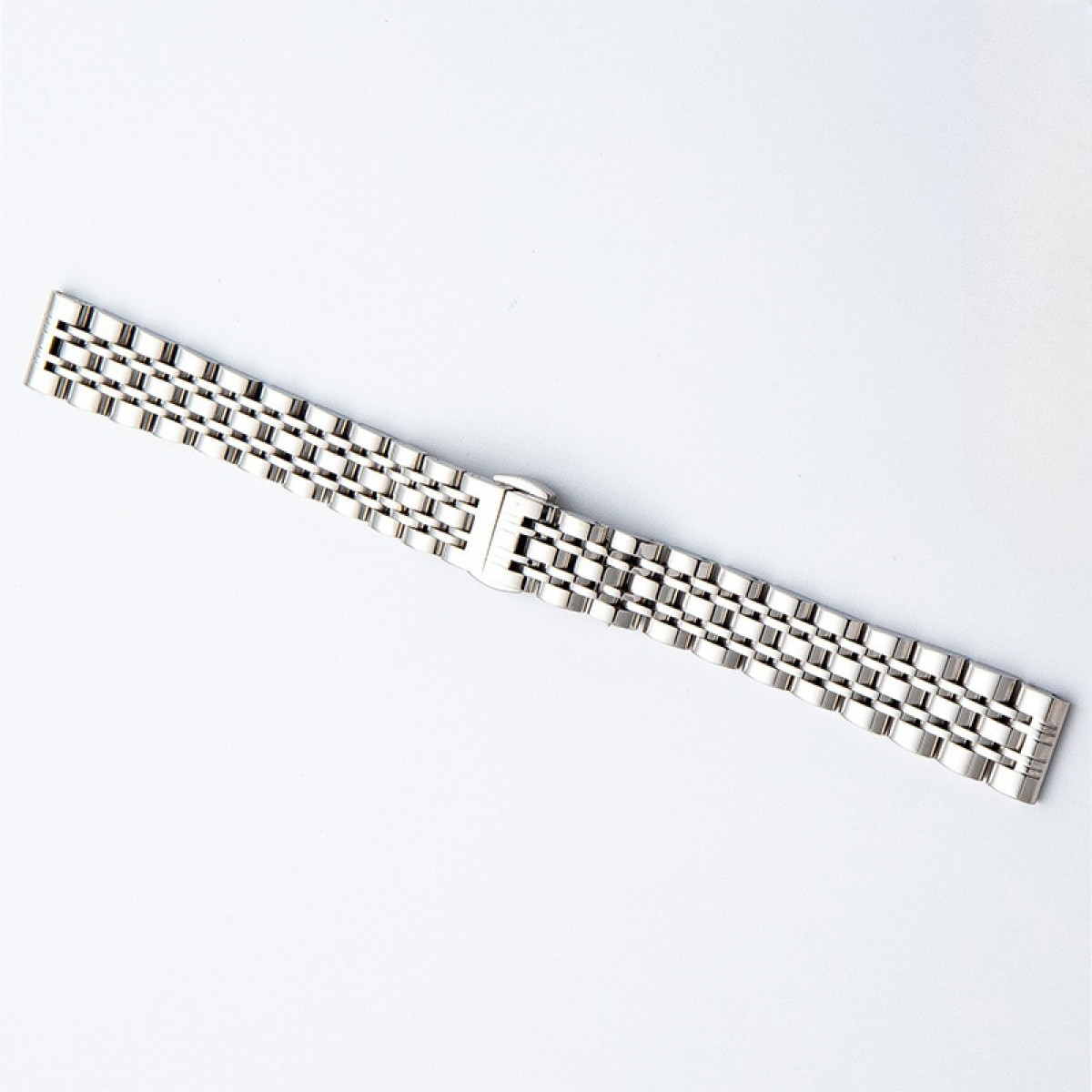 Silbernes Uhrenarmband mit Metallverschluss. Es ist auf weißem Hintergrund.