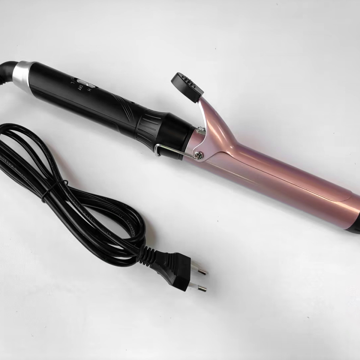 Arricciacapelli con manico nero e cilindro rosa. Il cavo e la spina sono visibili.