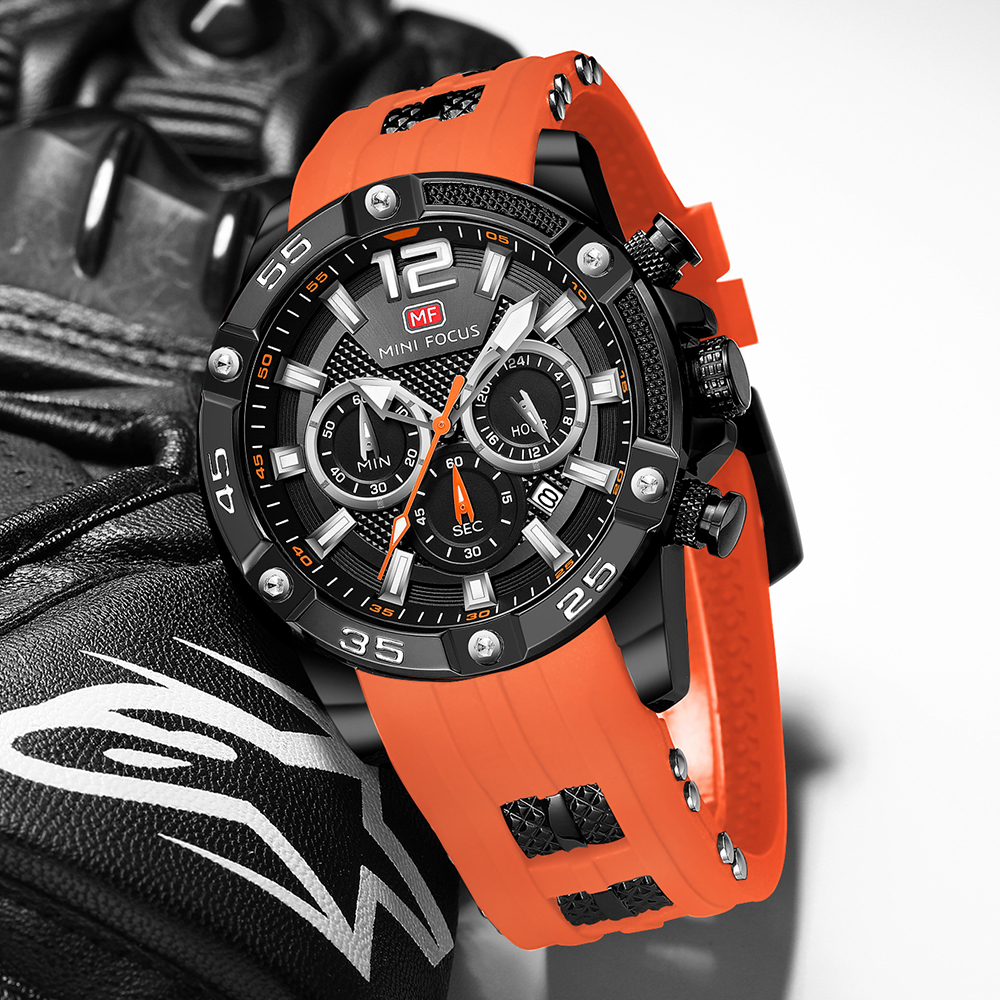 Eine schwarze und orange Uhr auf schwarzem Untergrund. Die Uhr hat viele Zifferblätter und ein schwarzes Armband.