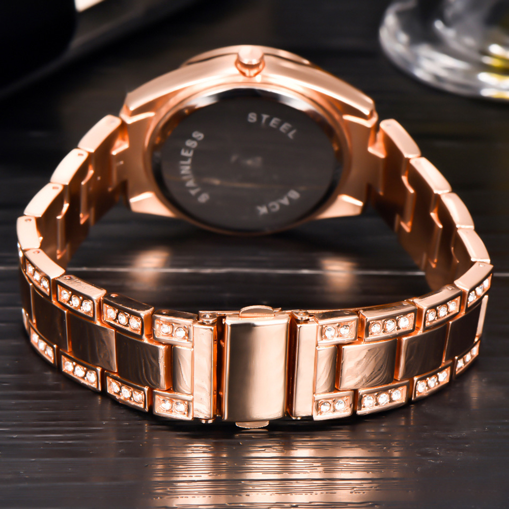 Roségoldene Uhr, Rückseite zeigend. Edelstahlrücken und Armband mit Kristallen auf dunkler Oberfläche.