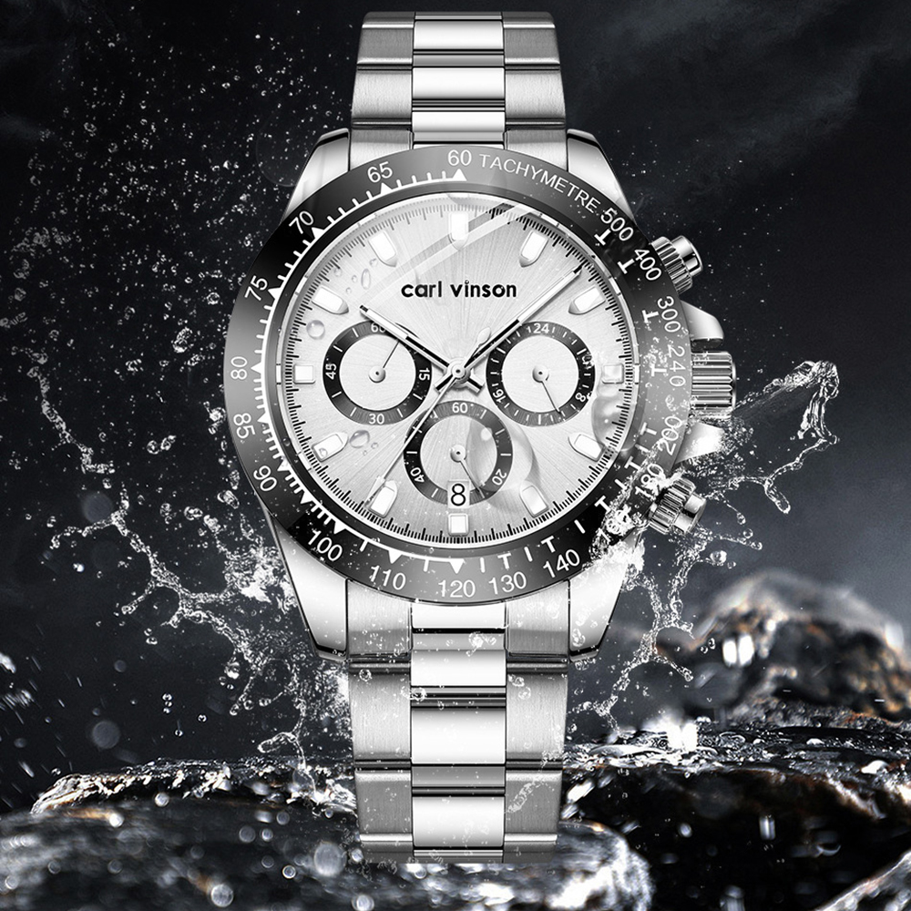 Eine silberne Uhr mit einer schwarz-weißen Lünette, vor einem Wasserspritzer-Hintergrund.