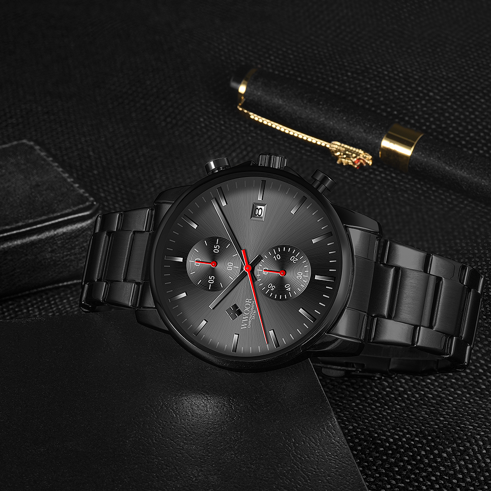 Eine schwarze Uhr mit schwarzem Armband und roten Akzenten auf schwarzem Untergrund.