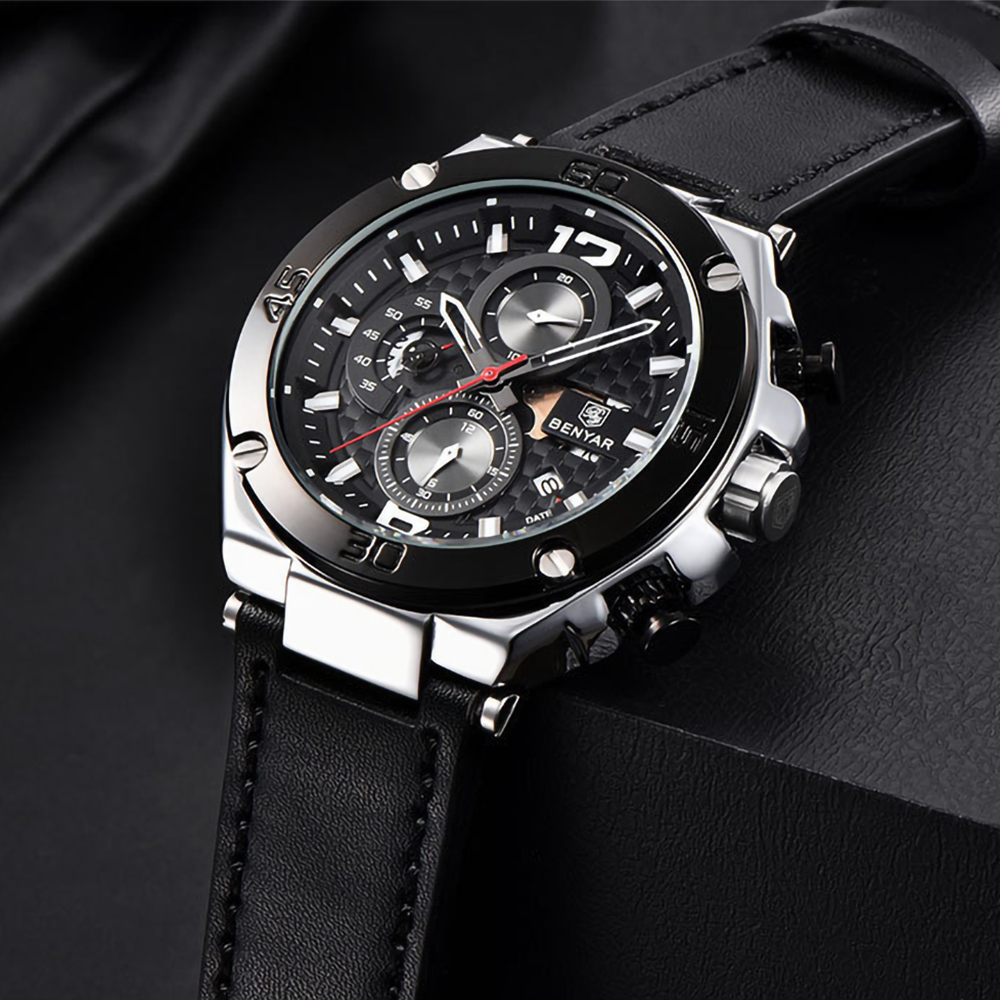 Schwarze Uhr mit schwarzem Lederarmband. Silberne Details, schwarzer Hintergrund.