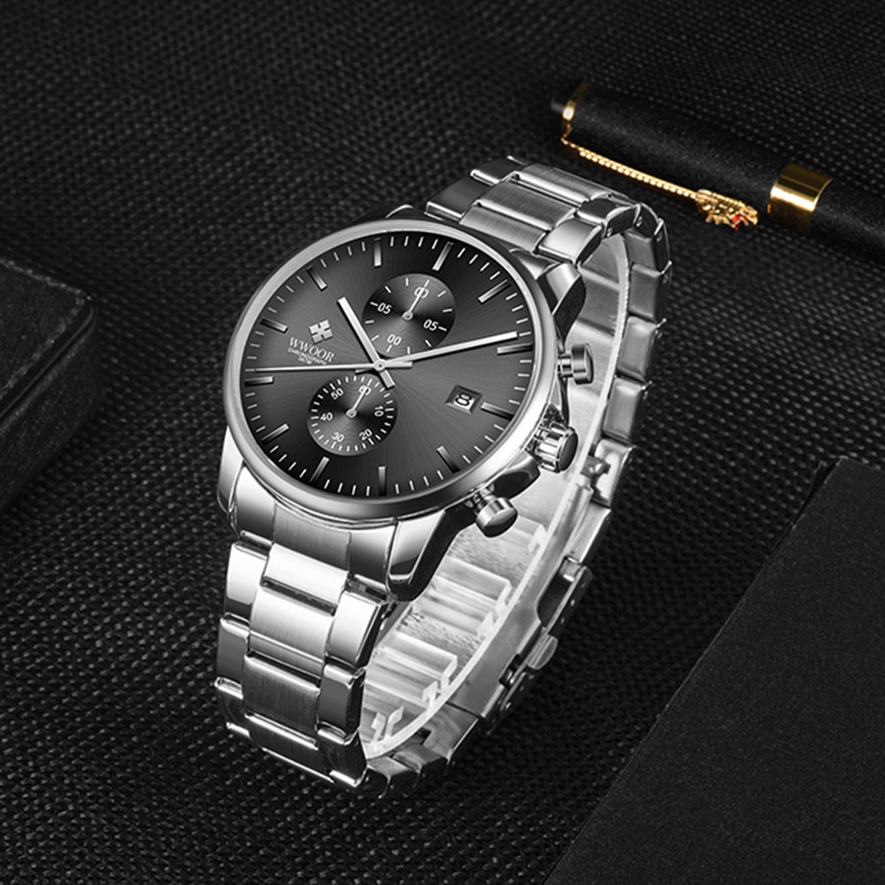 Eine silberne Uhr auf einer schwarzen Oberfläche. Die Uhr hat ein dunkles Zifferblatt und ein silbernes Armband.