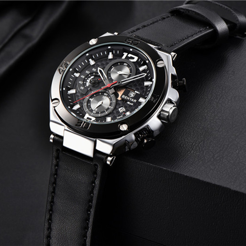 Nahaufnahme einer schwarzen Uhr mit silbernen Akzenten und einem schwarzen Lederarmband.