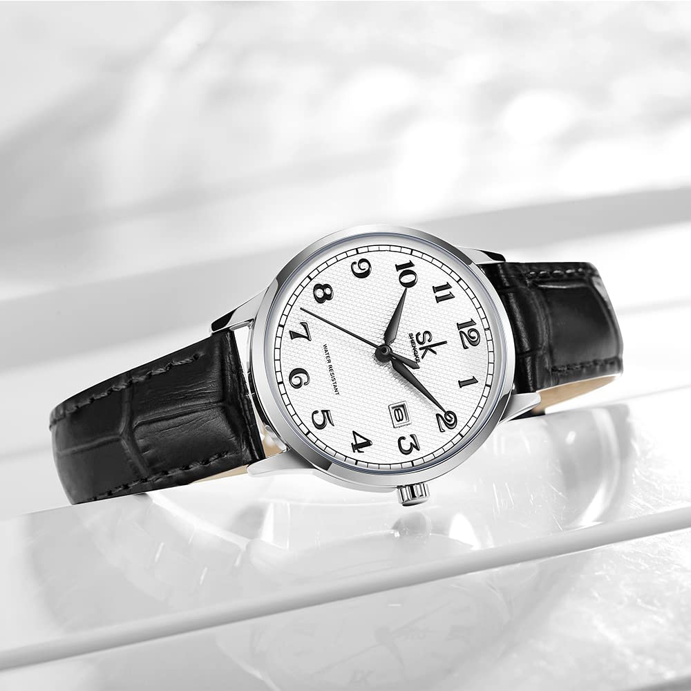 Eine silberne Uhr mit weißem Zifferblatt, schwarzen Zahlen und einem schwarzen Lederarmband.