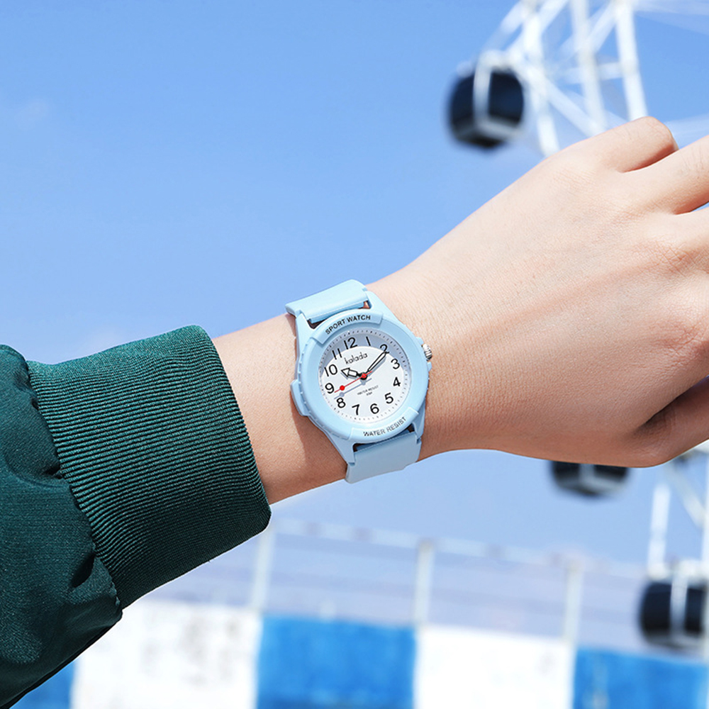 Hellblaue Sportuhr am Handgelenk, im Hintergrund ein Riesenrad.