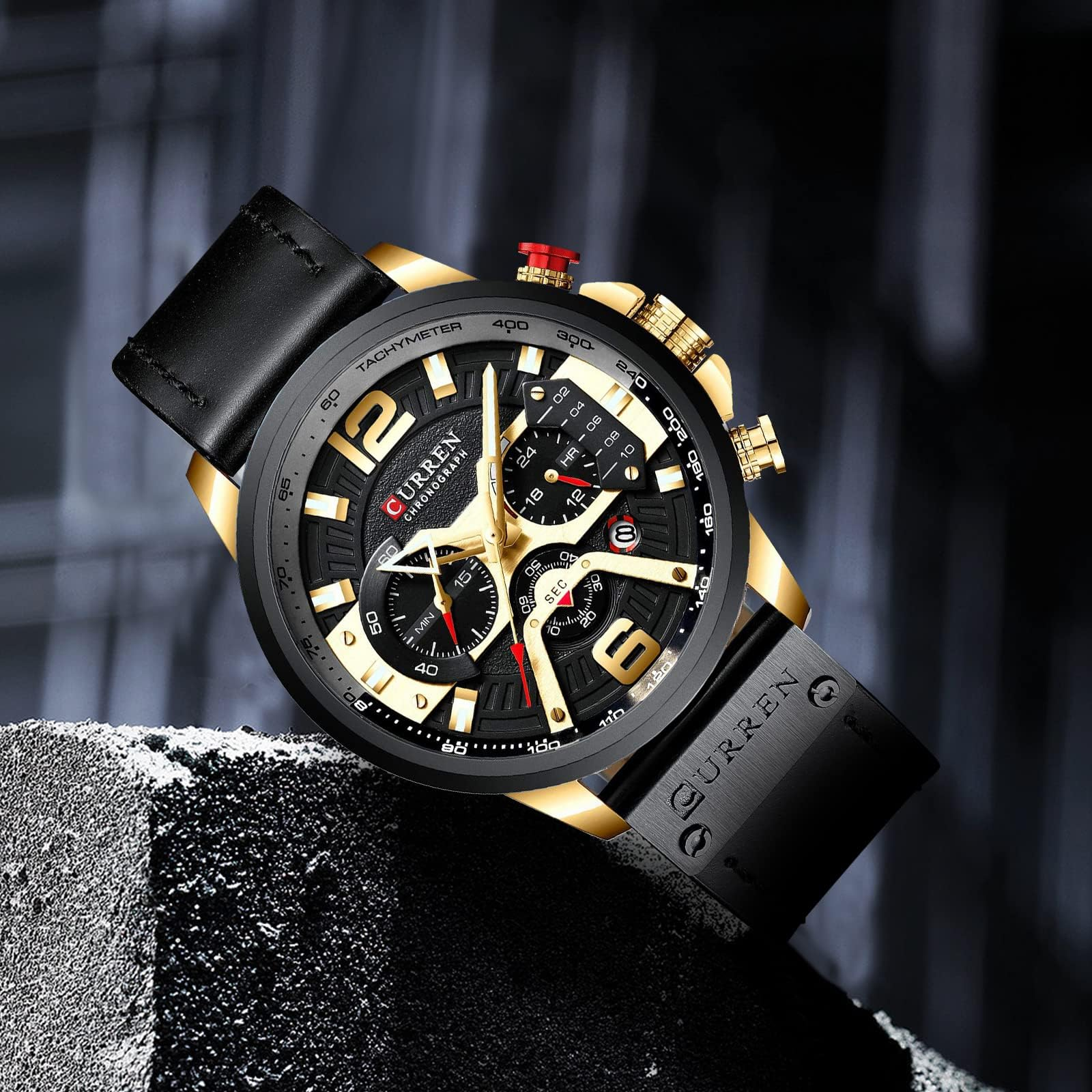 Goldene und schwarze Uhr auf schwarzer Oberfläche.