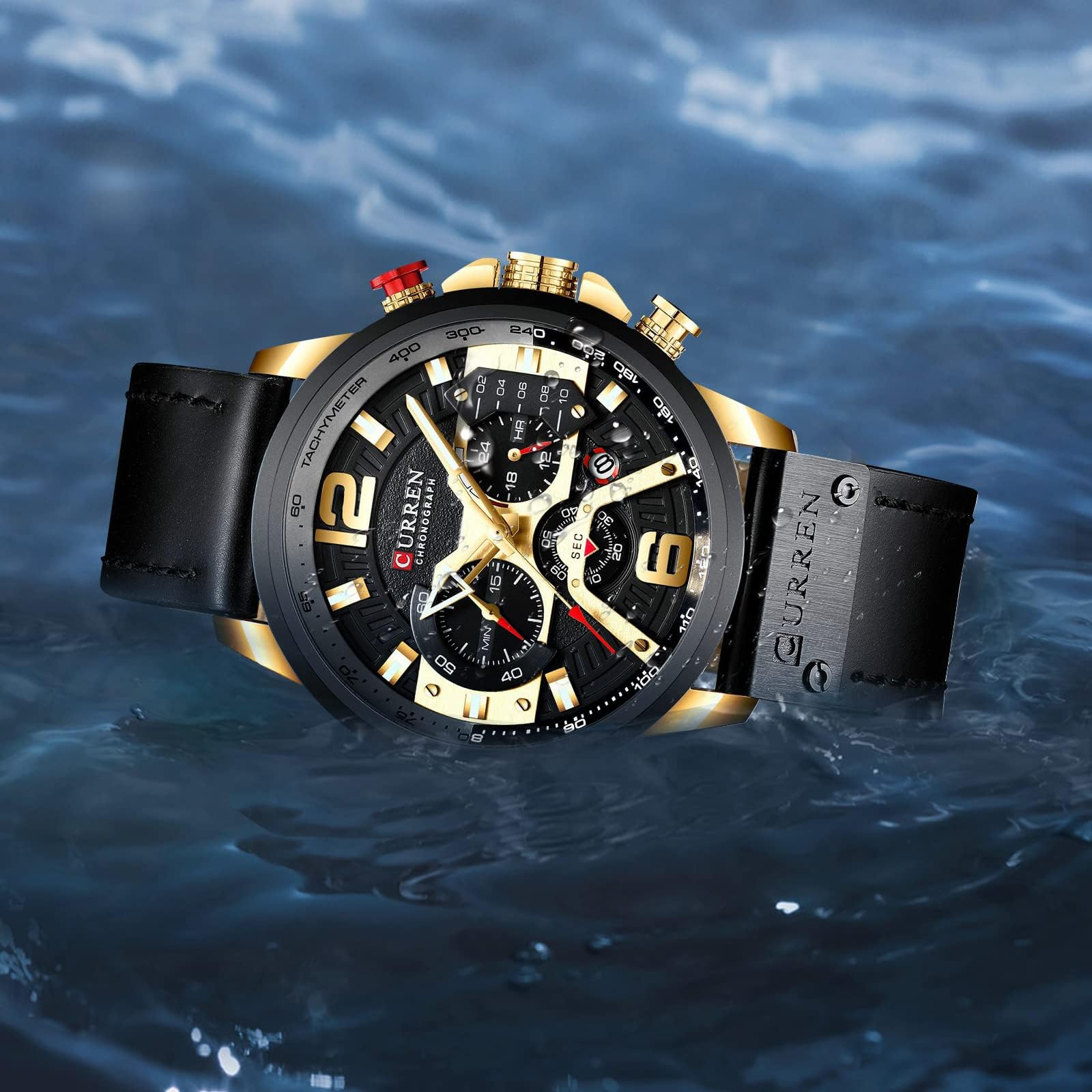 Eine goldene und schwarze Armbanduhr, die in blauem Wasser untergetaucht ist. Die Uhr hat ein schwarzes Lederarmband und eine goldene Lünette.