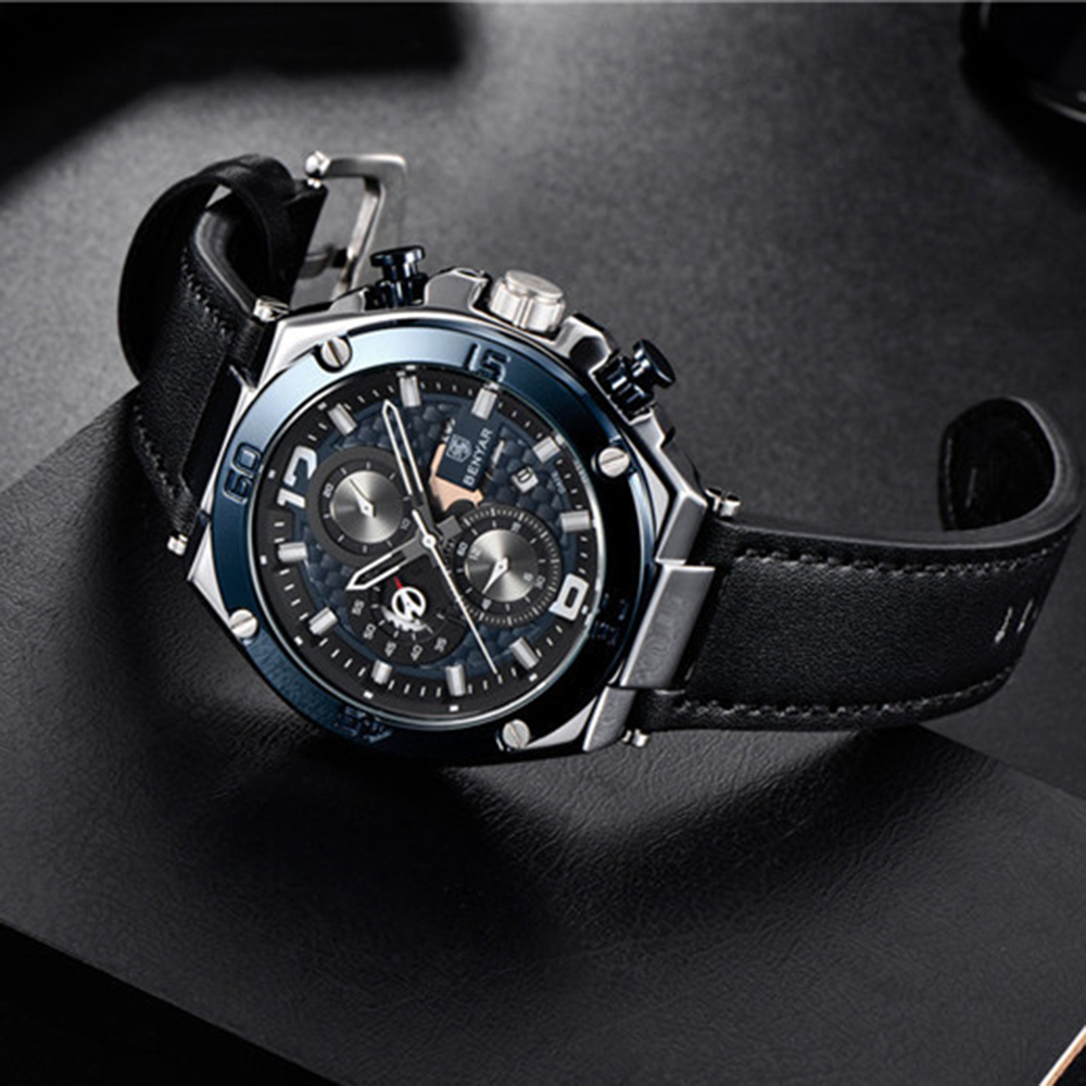 Schwarze Uhr mit blauem Zifferblatt und schwarzem Lederarmband.