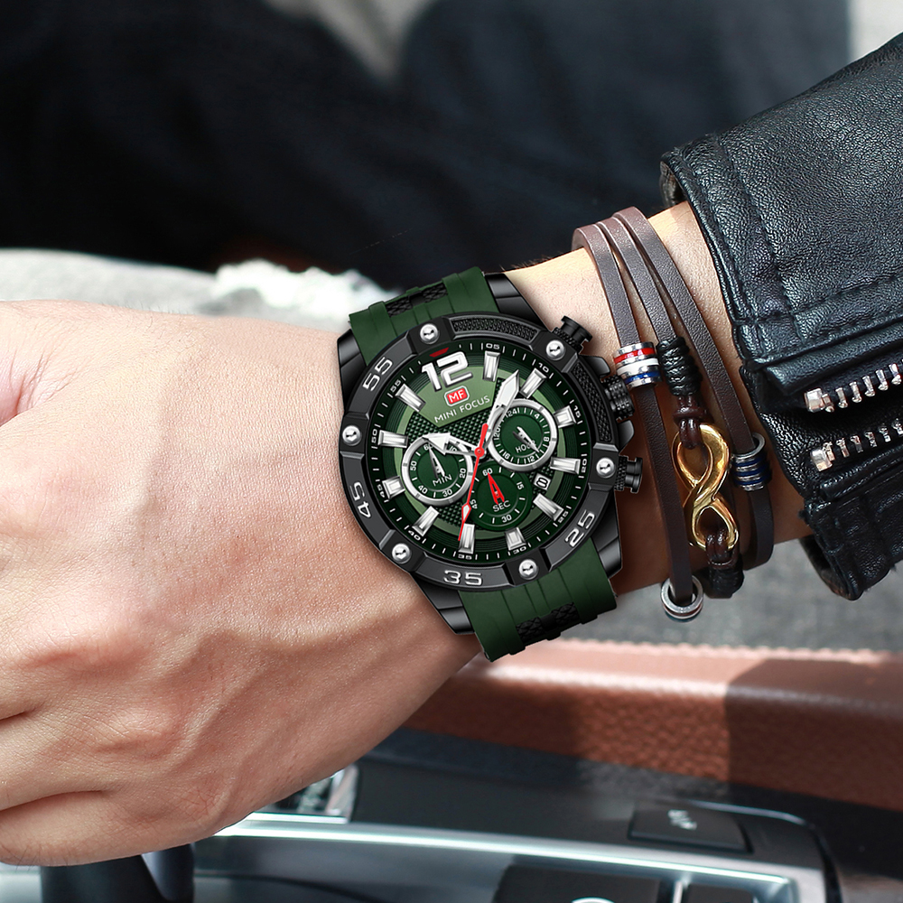 Armbanduhr mit grünem Armband, schwarzem Zifferblatt und drei Lederarmbändern.