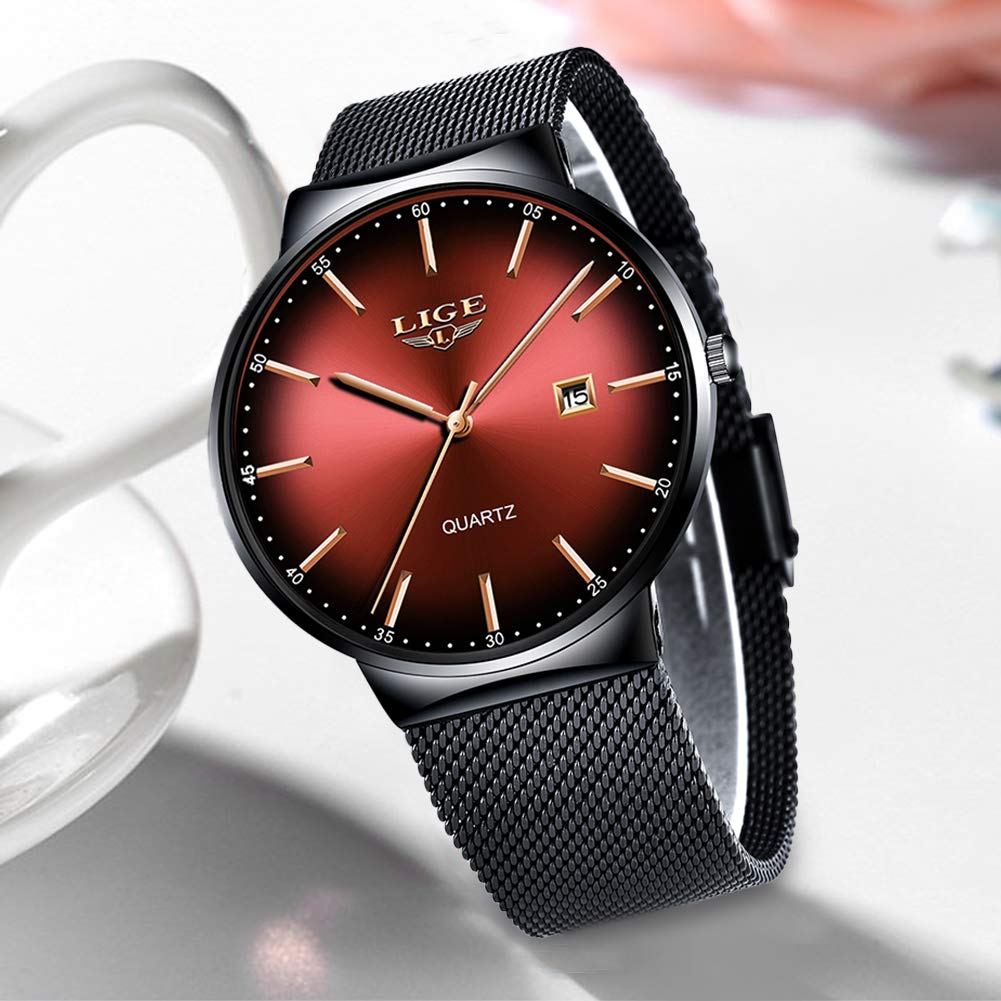 Rote Uhr mit schwarzem Mesh-Armband. Goldene Zeiger und Markierungen auf rotem Zifferblatt.
