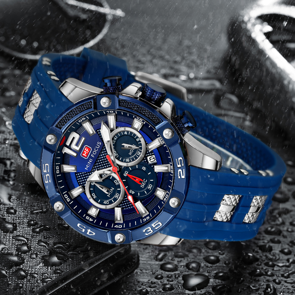 Eine blaue Uhr auf einer nassen Oberfläche. Die Uhr hat ein dunkelblaues Zifferblatt und ein blaues Armband.