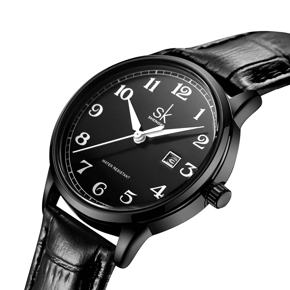 Schwarze Uhr mit weißen Ziffern und Zeigern, schwarzes Lederarmband, Nahaufnahme, weißer Hintergrund.