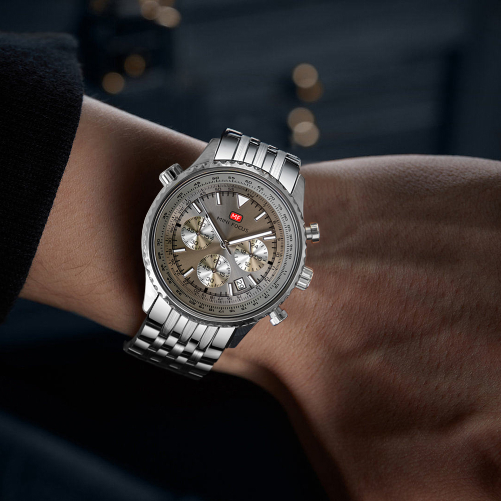 Eine silberne Uhr mit braunem Zifferblatt am Handgelenk, mit Metallarmband.