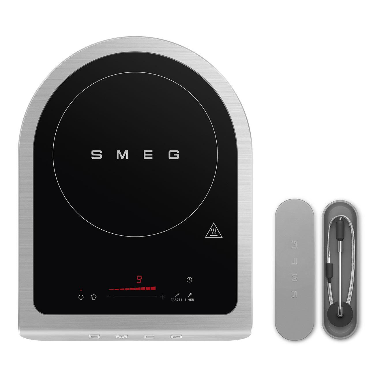 Une plaque à induction argentée avec une surface de cuisson noire. Un thermomètre séparé est posé à proximité.