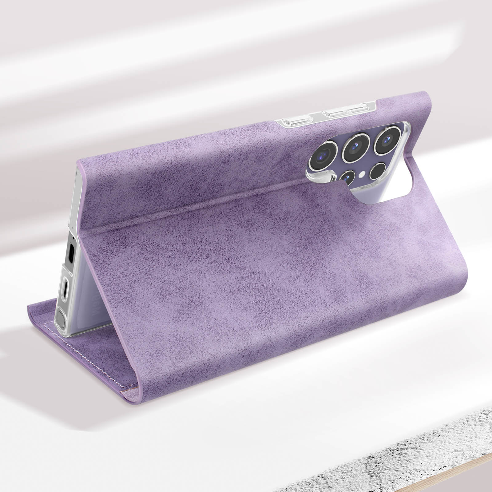 Custodia per telefono viola, aperta, che sorregge un telefono. Superficie bianca. Obiettivo della fotocamera e pulsanti esposti.