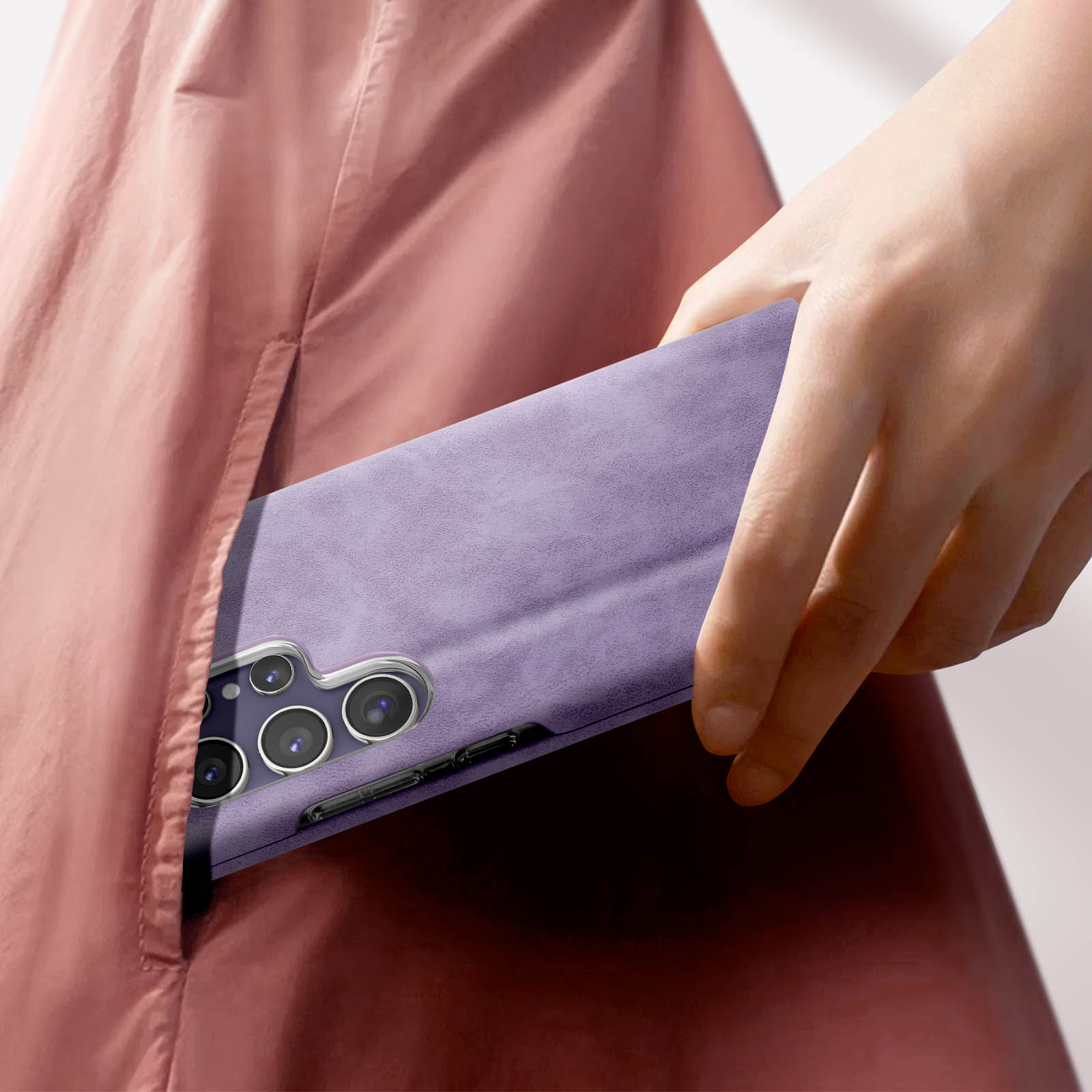 Una mano che mette una custodia viola in tasca. Il telefono è nella custodia.