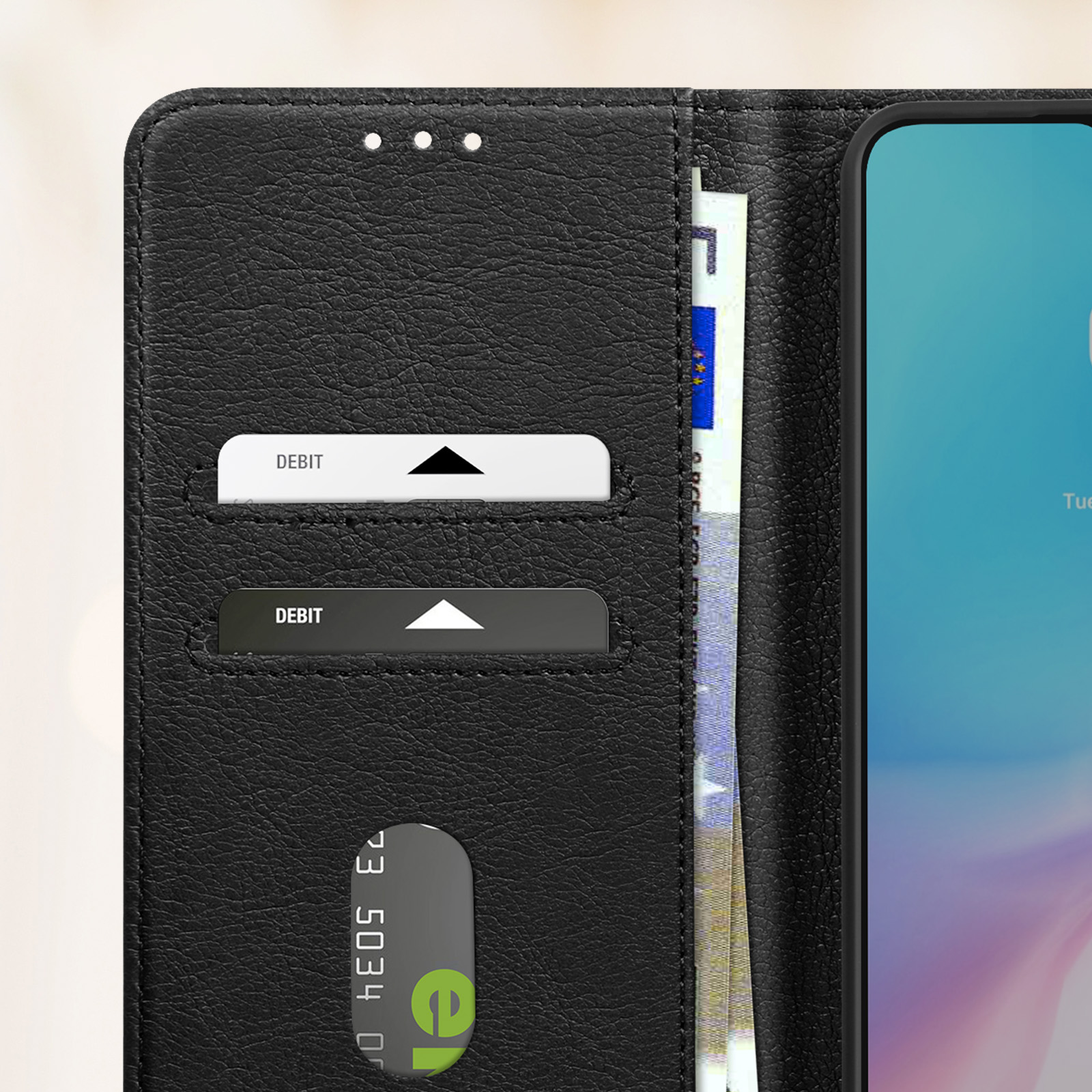Un primo piano dell'interno di una custodia nera con fessure per carte di debito e denaro. Il telefono è visibile.