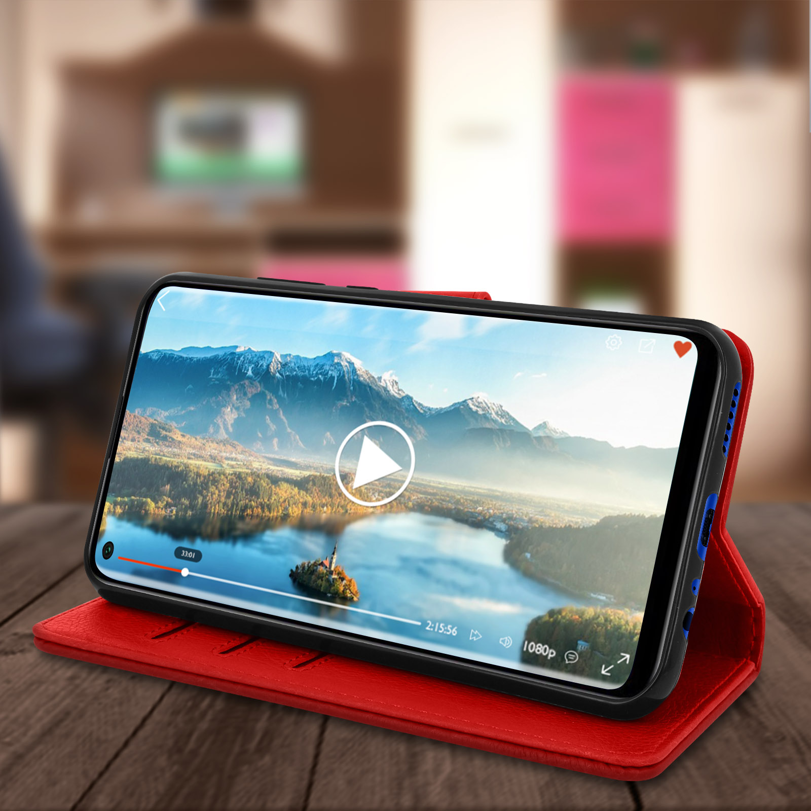 Custodia per telefono rossa con un telefono che riproduce un video. Il telefono è su una superficie di legno.