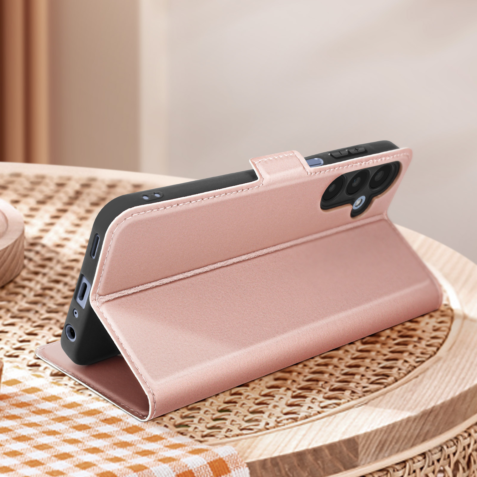 Custodia rosa per telefono su un tavolo di legno. La custodia è aperta e supporta il telefono.