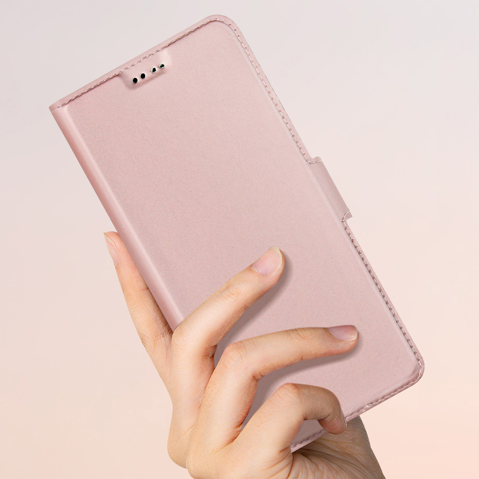 La mano di una persona che tiene una custodia per telefono rosa. La custodia è aperta.