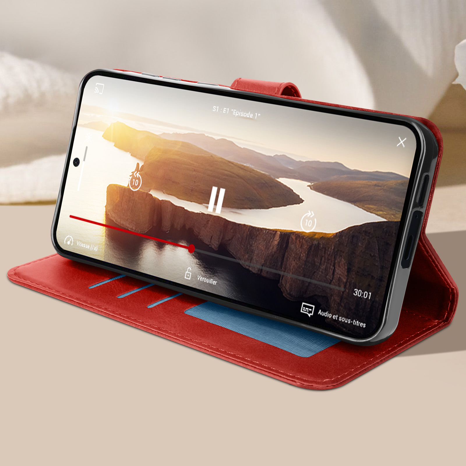 Custodia per telefono rossa aperta con telefono che mostra un video. Tre scomparti blu per carte visibili.