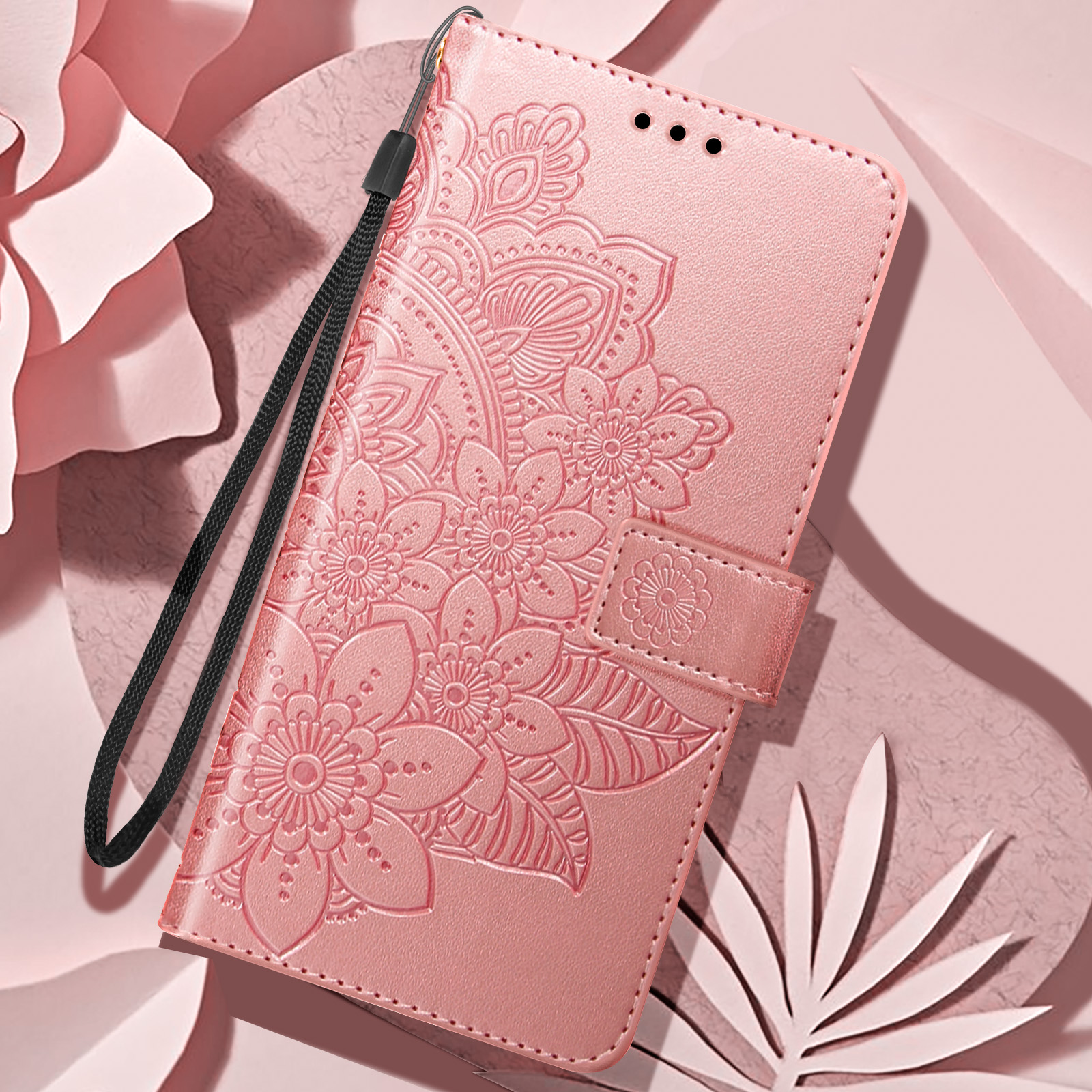 Custodia per telefono rosa con design floreale in rilievo, chiusura e cinturino, su sfondo rosa.