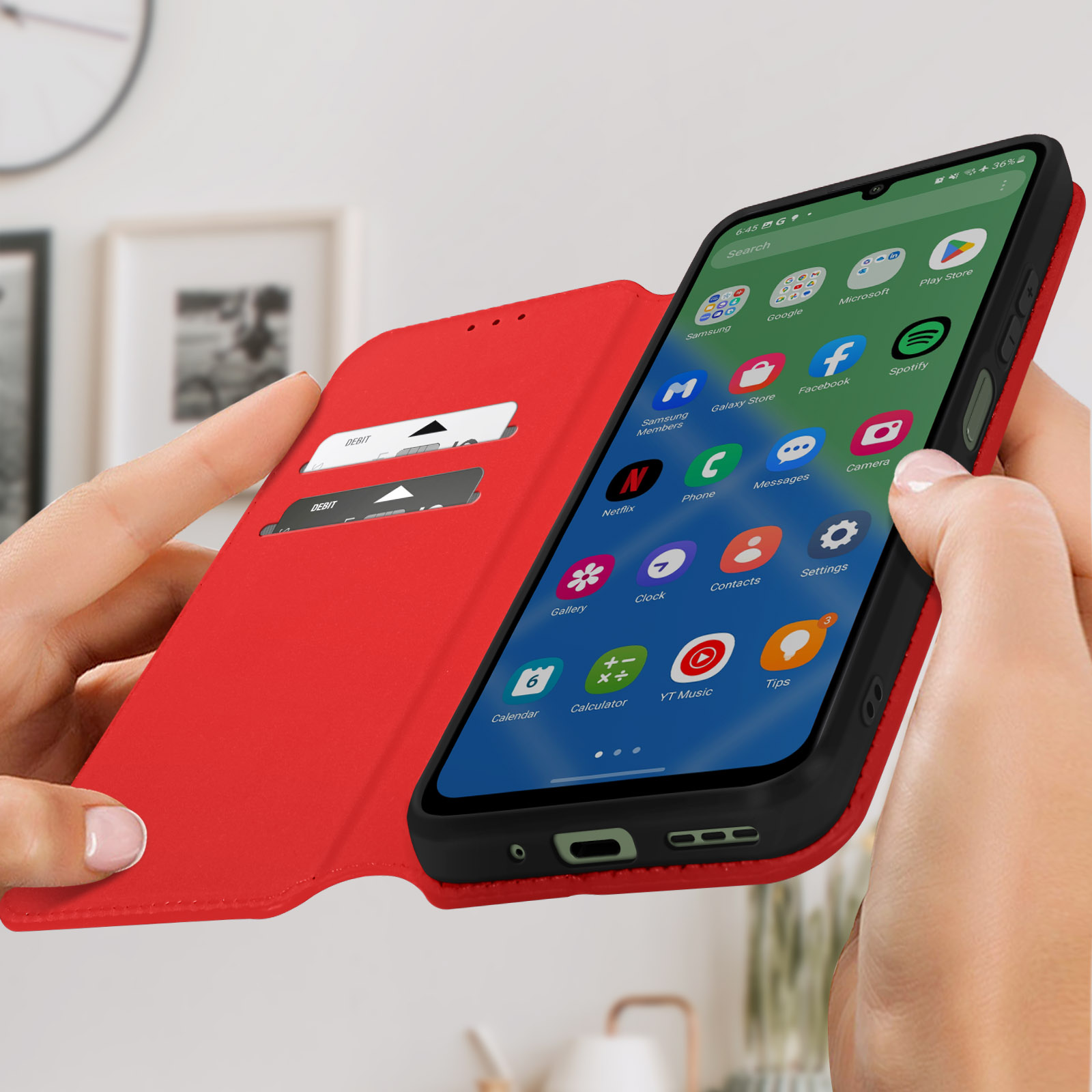Mani che tengono aperta una custodia rossa, che mostra lo schermo di un telefono con icone di app.
