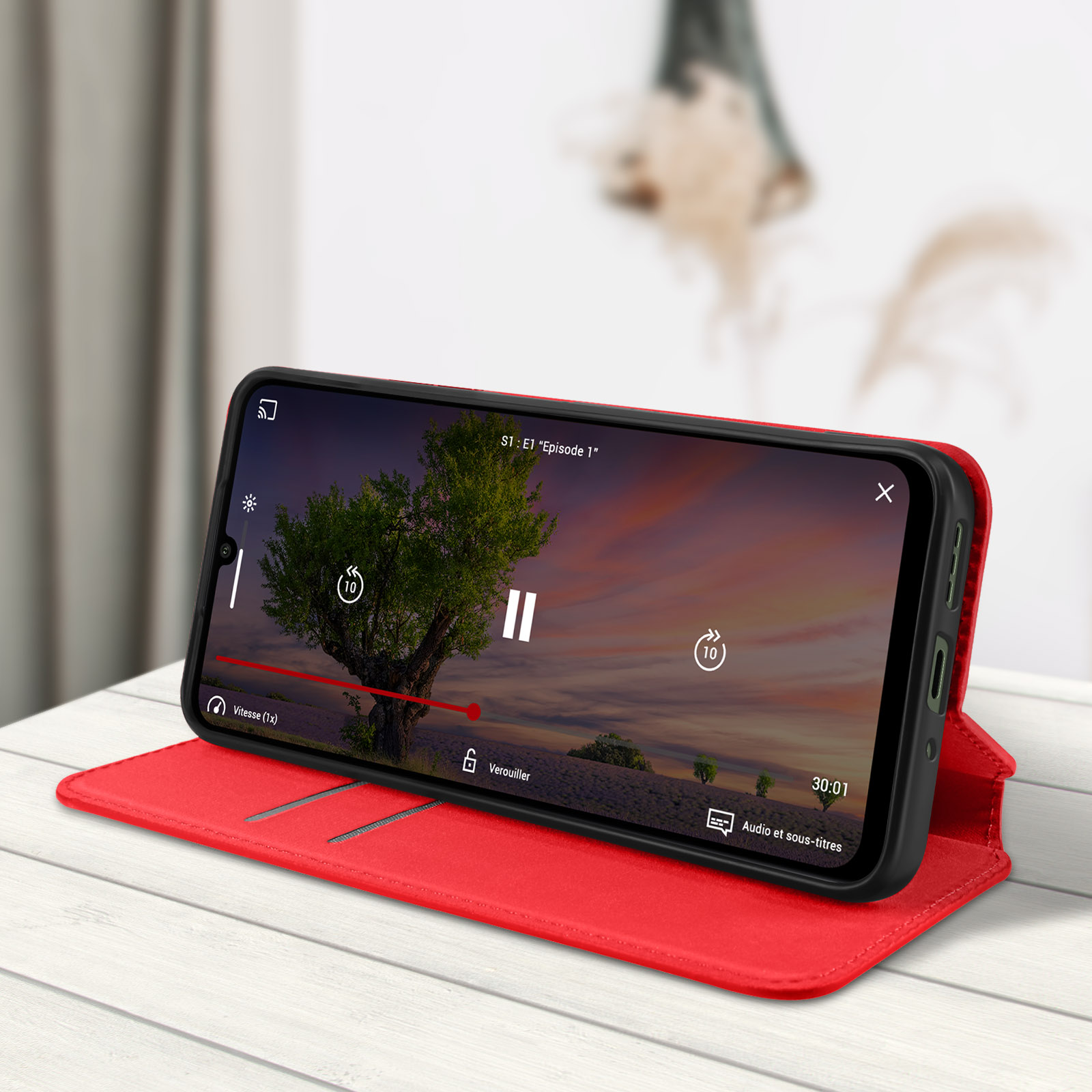 Custodia per telefono rossa, aperta, che mostra un telefono con un video in riproduzione.
