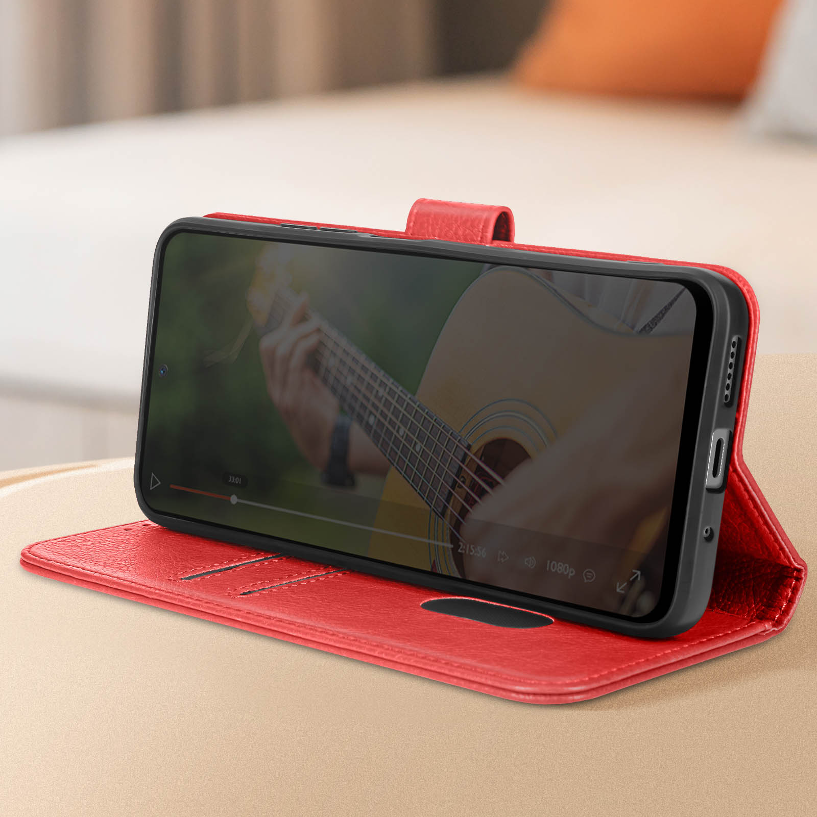 Rote Handyhülle. Telefon spielt Video eines Gitarristen ab.