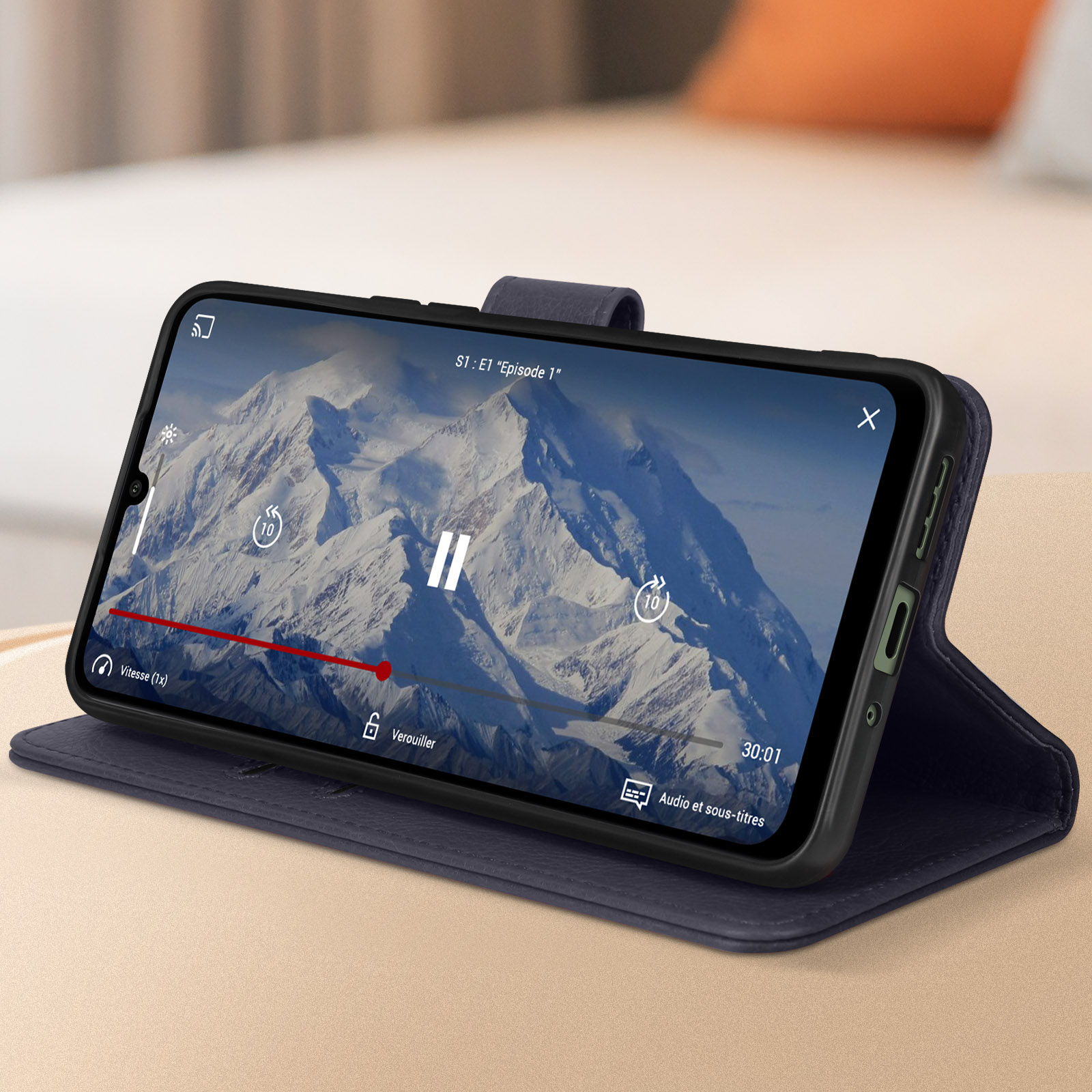 Telefon spielt Video in blauem Etui. Berglandschaft auf dem Bildschirm. Geöffnete Position.