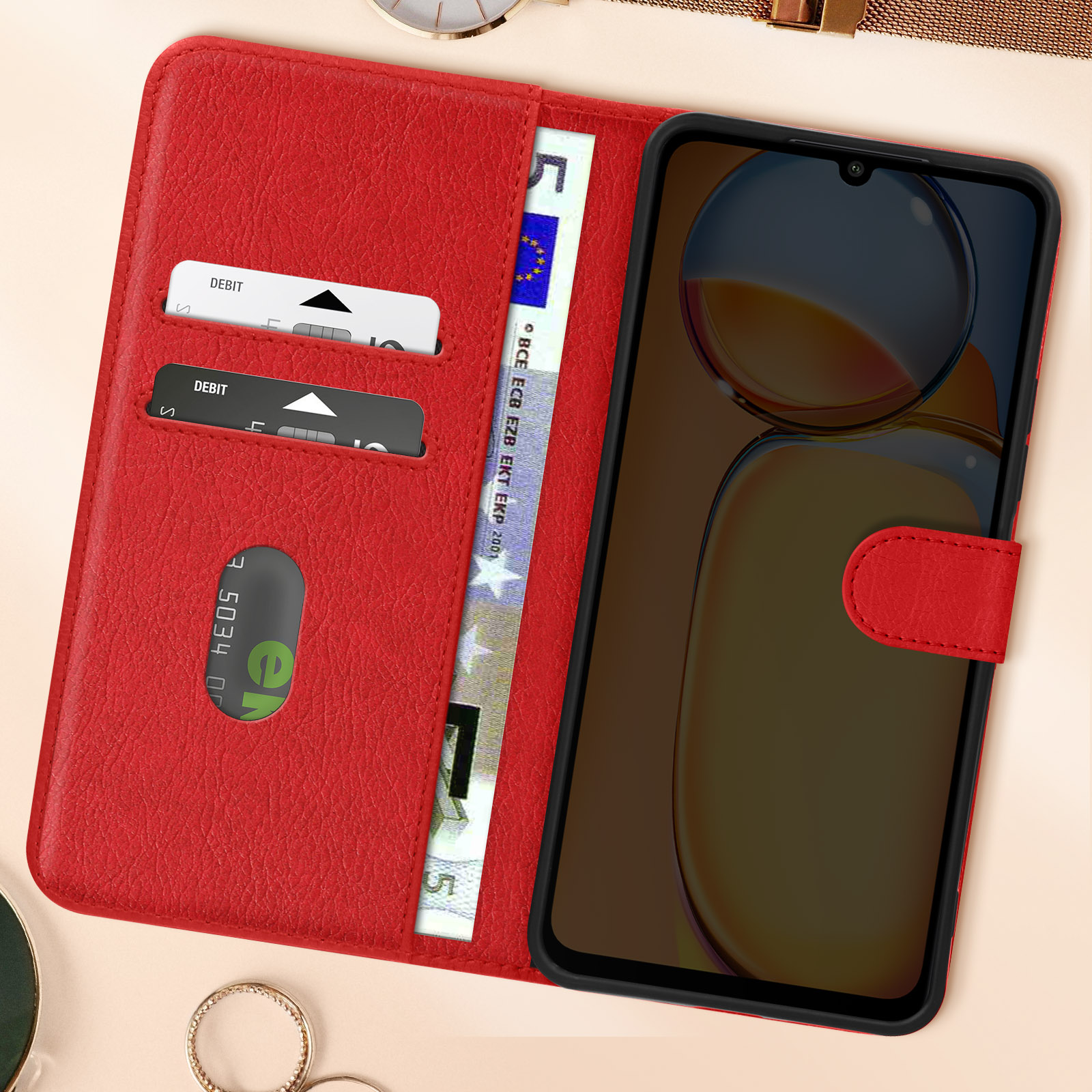 Una custodia per telefono rossa con carte di credito e un telefono dentro. Aperta.