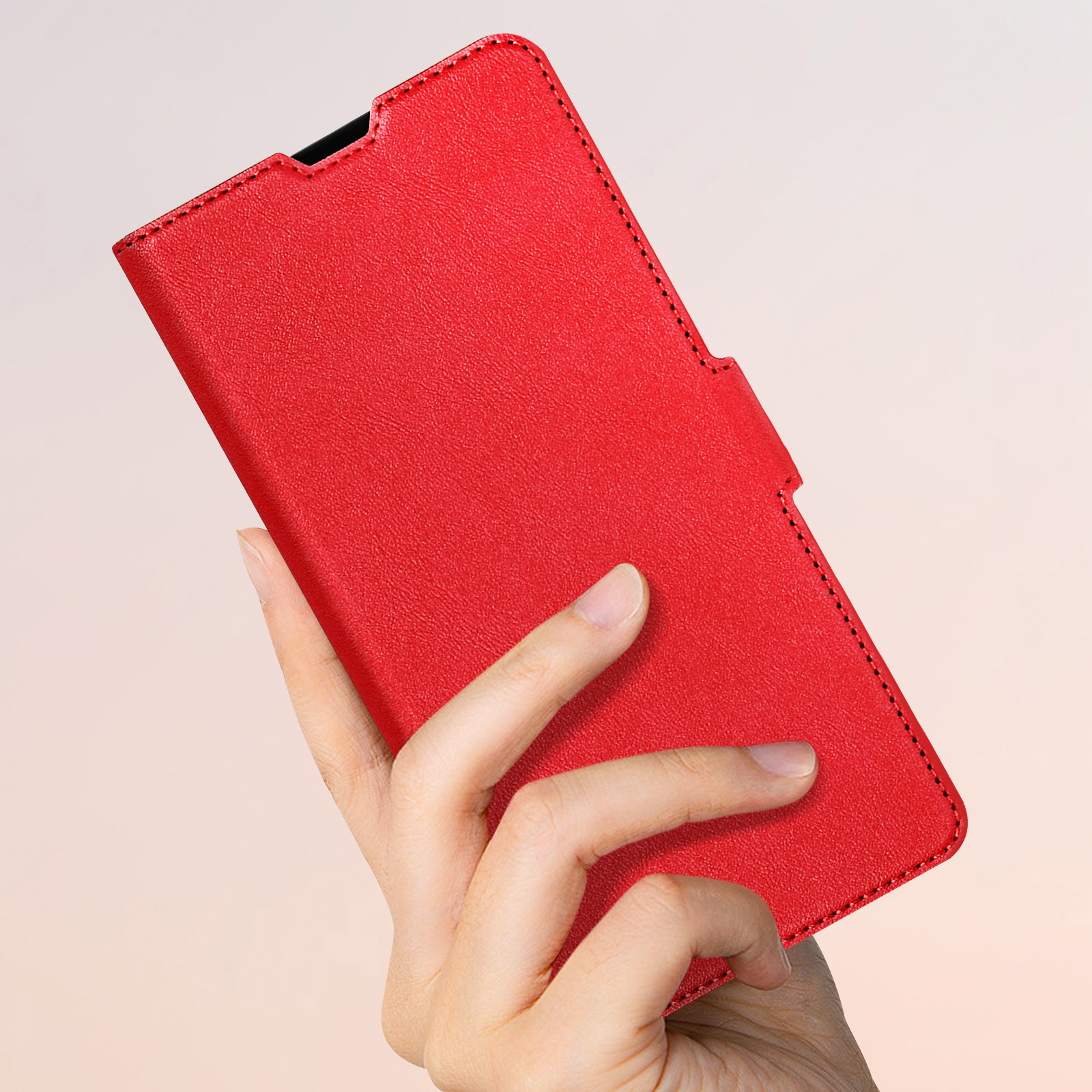Rote Handyhülle, die von einer Hand gehalten wird. Die Hülle ist einfarbig rot, Nahaufnahme.