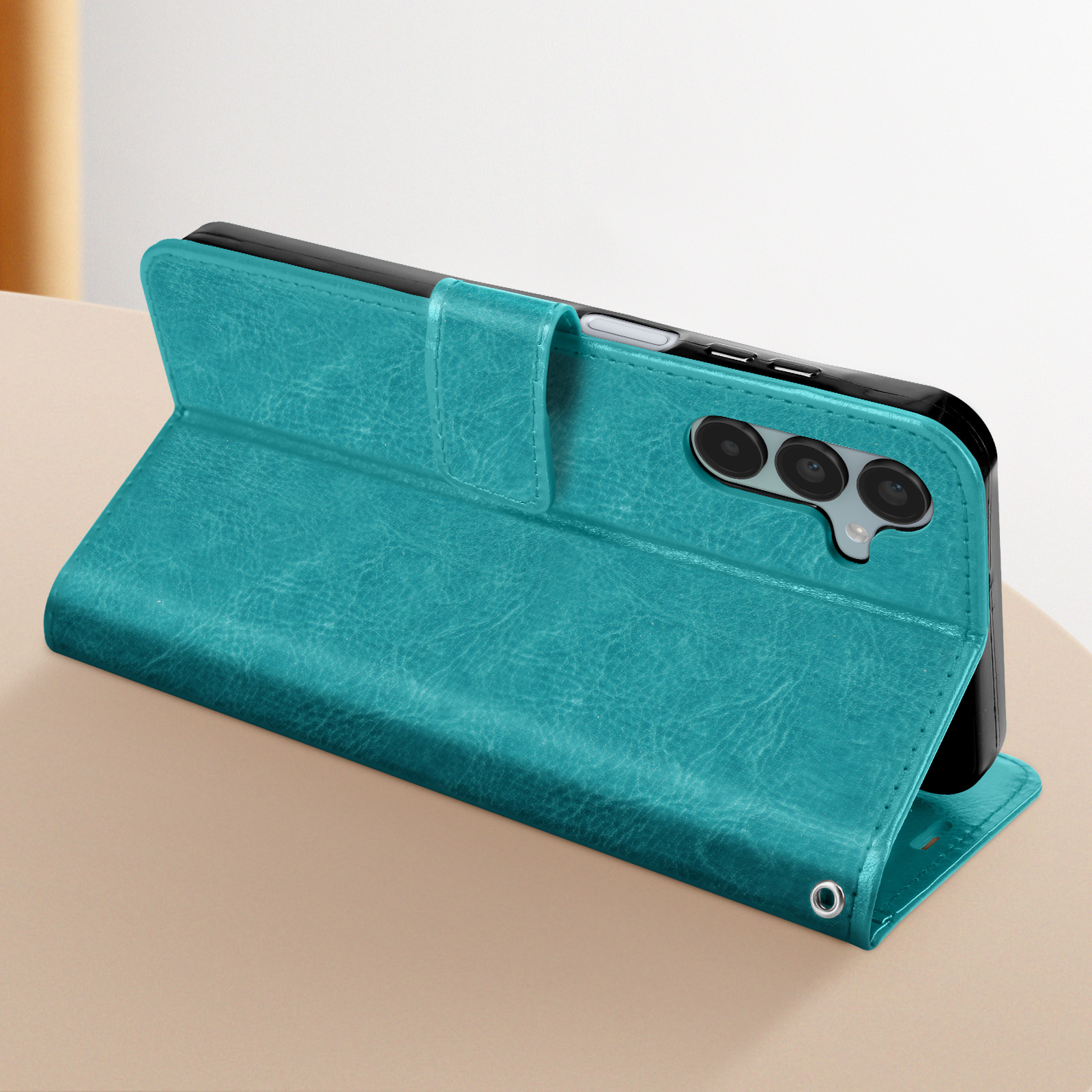 Custodia per telefono verde acqua aperta per mostrare un telefono. Chiusura magnetica, su un tavolo.