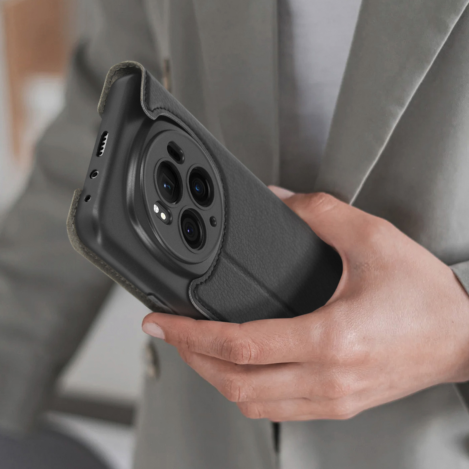 Persona che tiene una custodia nera per telefono. La custodia circonda il telefono, mostrando la fotocamera e i pulsanti.