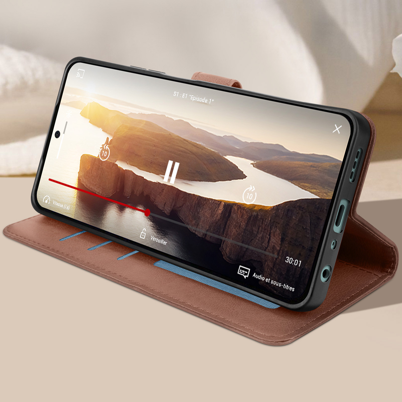 Custodia marrone per telefono aperta, telefono all'interno che riproduce un video. Fessure blu visibili.