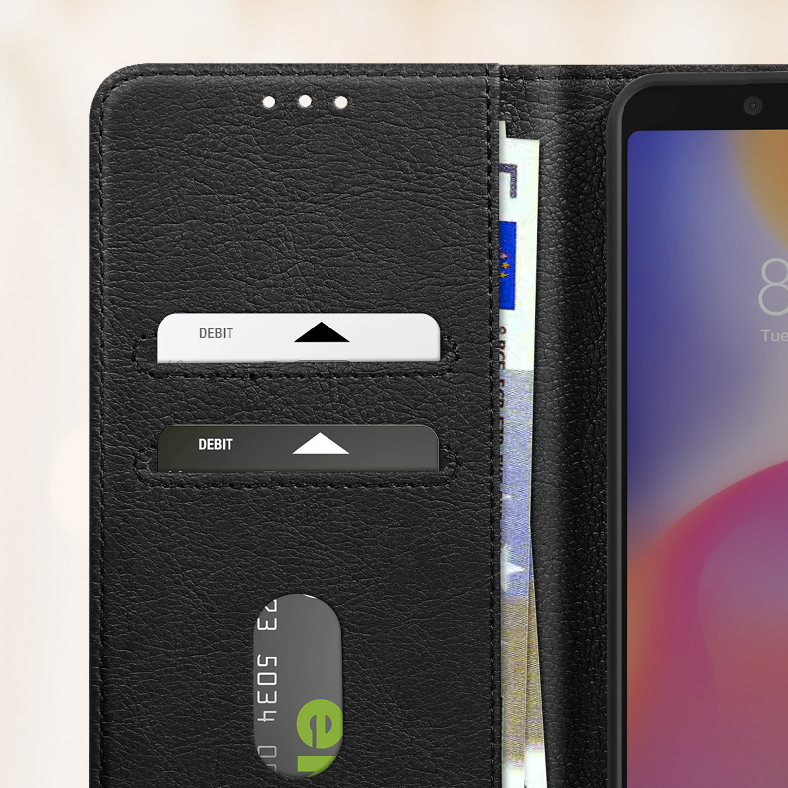 Custodia per telefono nera, aperta. Carte e denaro all'interno. Telefono a destra. Sfondo nero.