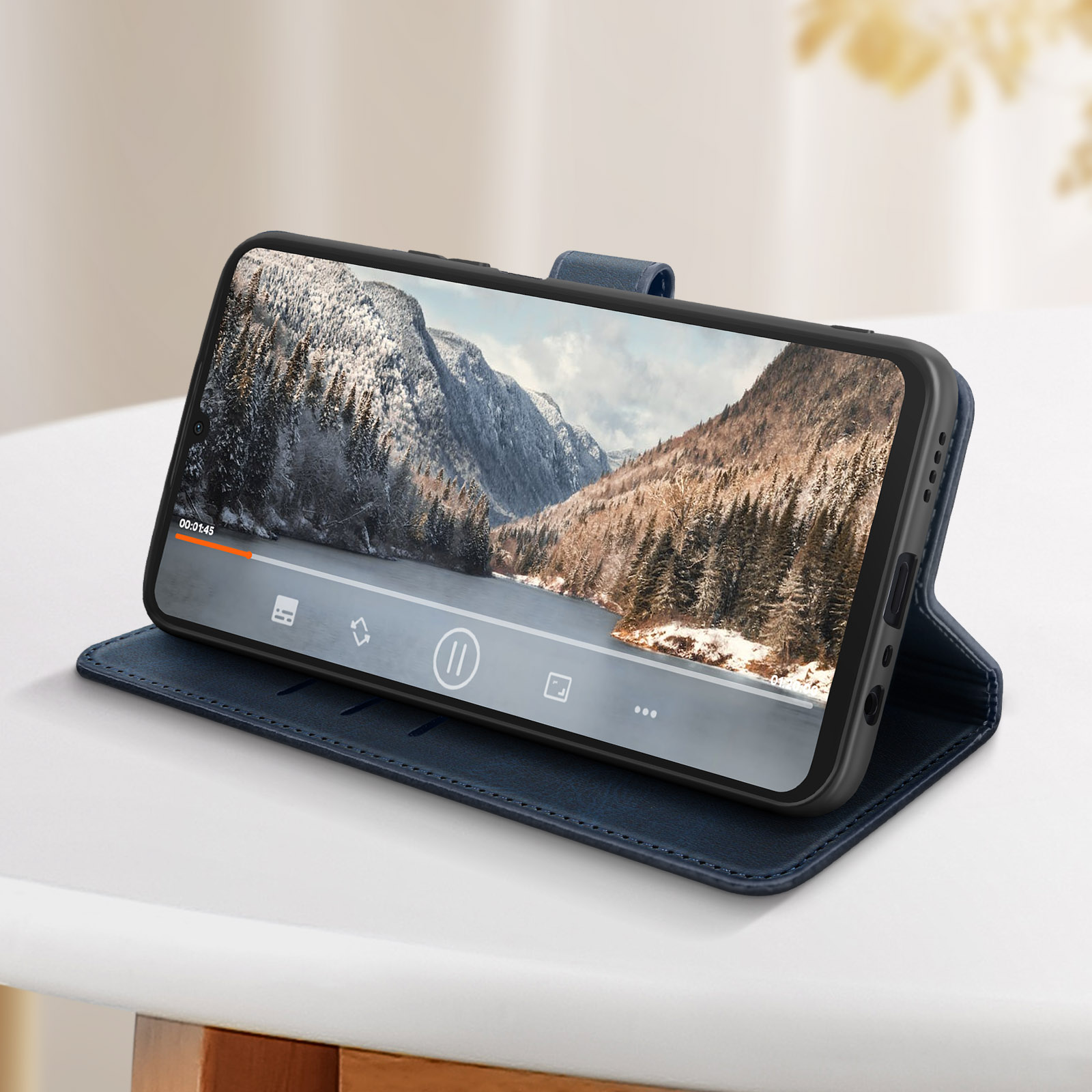 Custodia blu in modalità supporto, che mostra un telefono che riproduce un video di un paesaggio innevato.