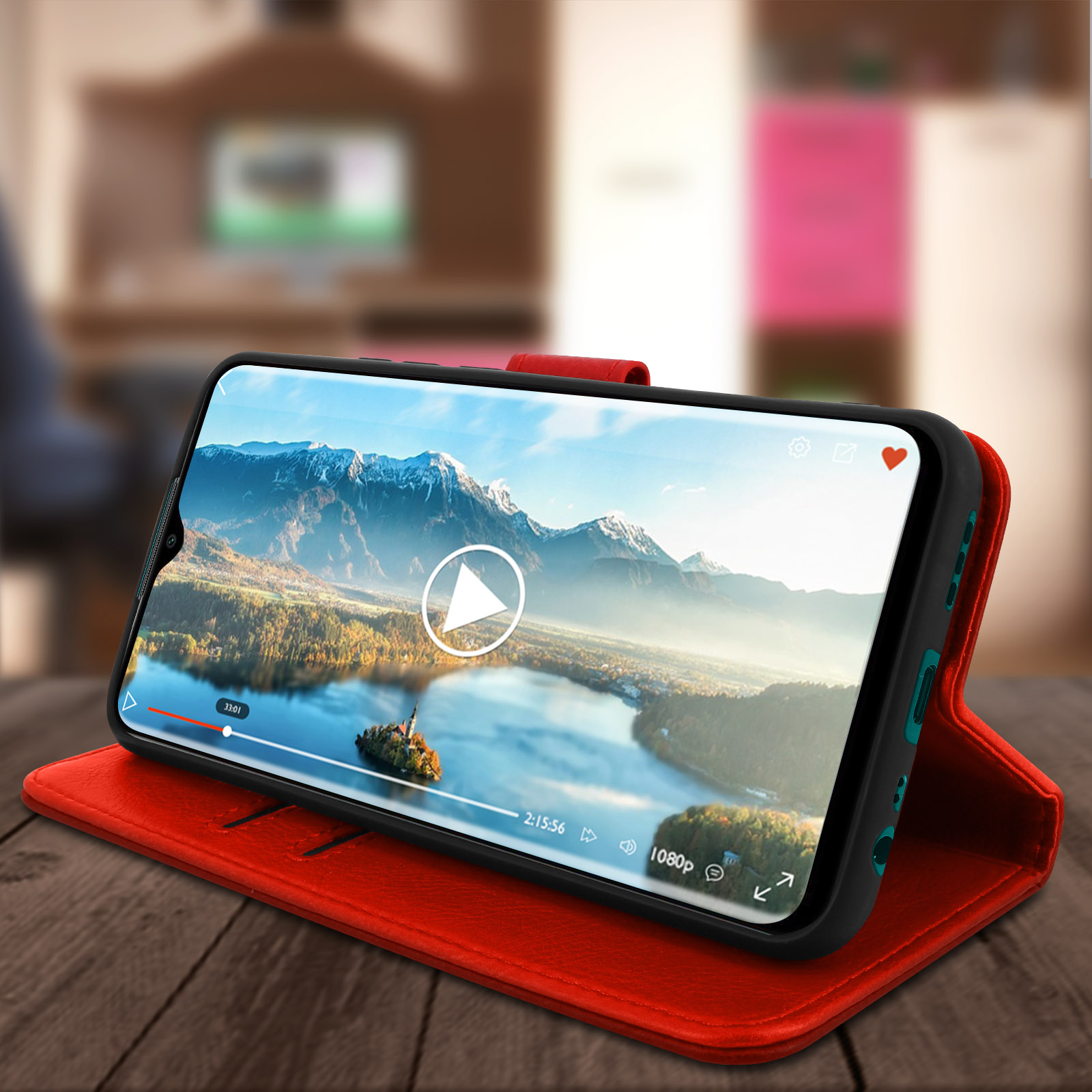 Telefono che mostra un video su una custodia rossa posta su un tavolo di legno. Lo sfondo mostra una stanza.
